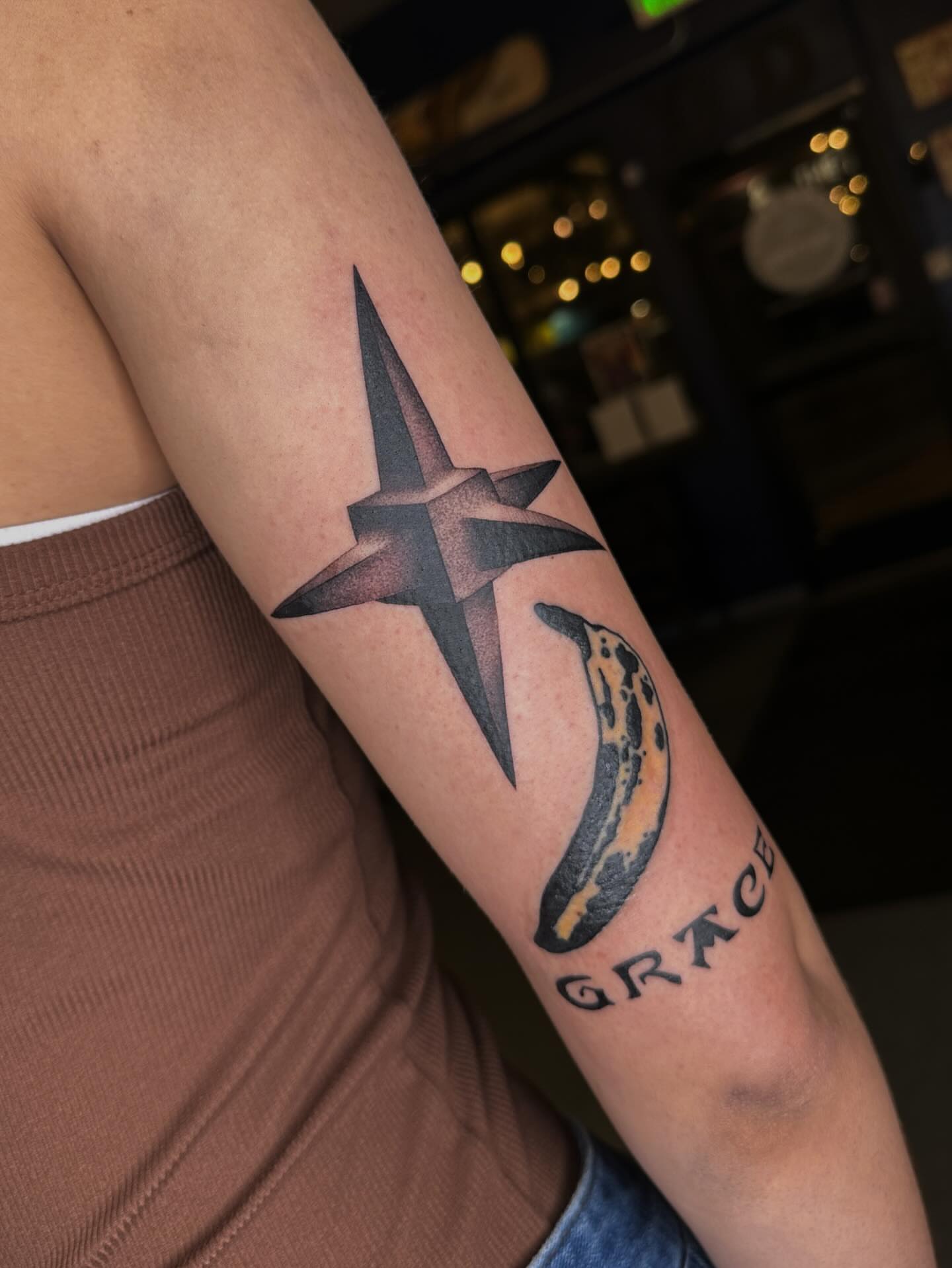 Cross and banana black and grey tattoo on the forearm by Aleksandra