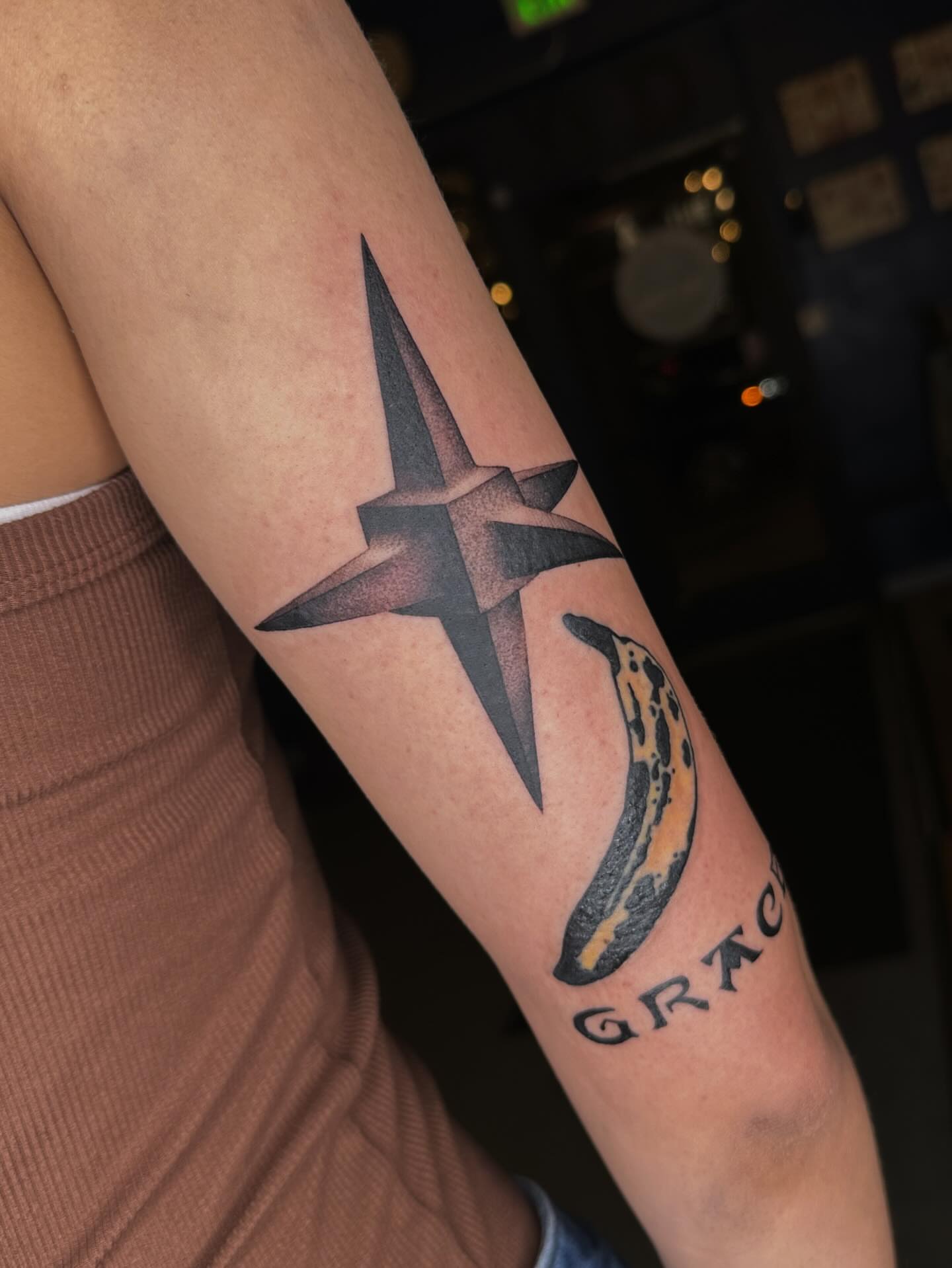 Star and banana black and grey tattoo on the forearm by Aleksandra