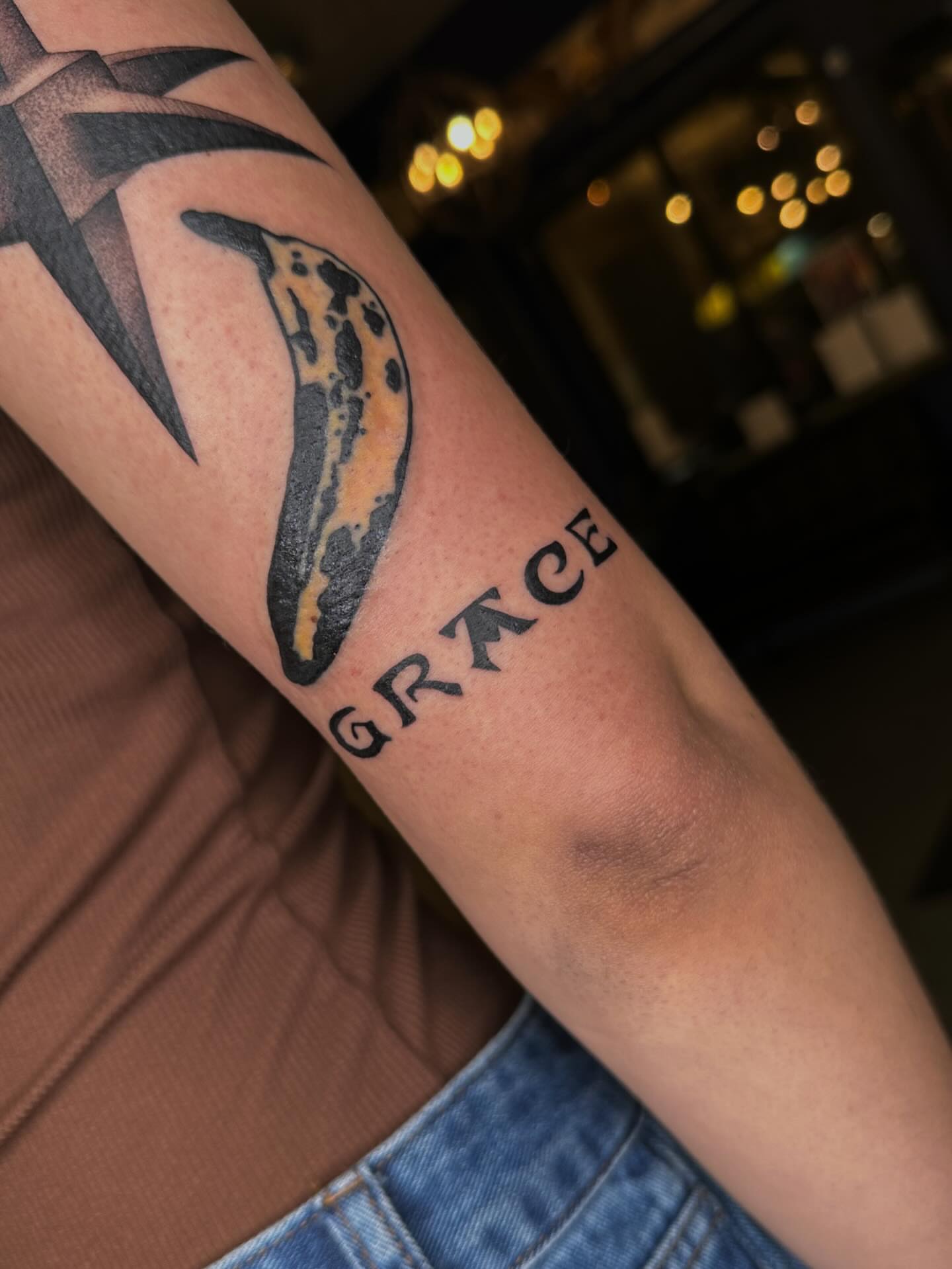Dolphin black and grey tattoo on the forearm by Aleksandra