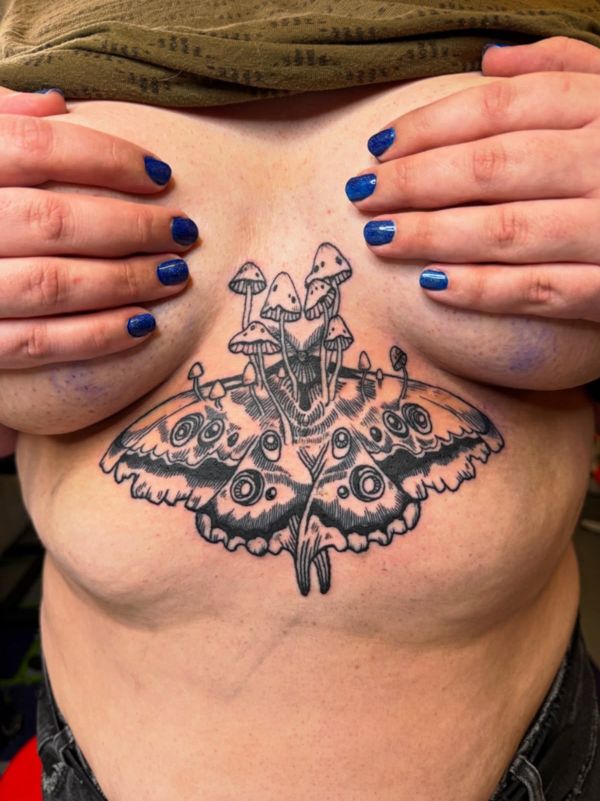 Butterfly and mushrooms black and grey tattoo on the chest by Emma Berger