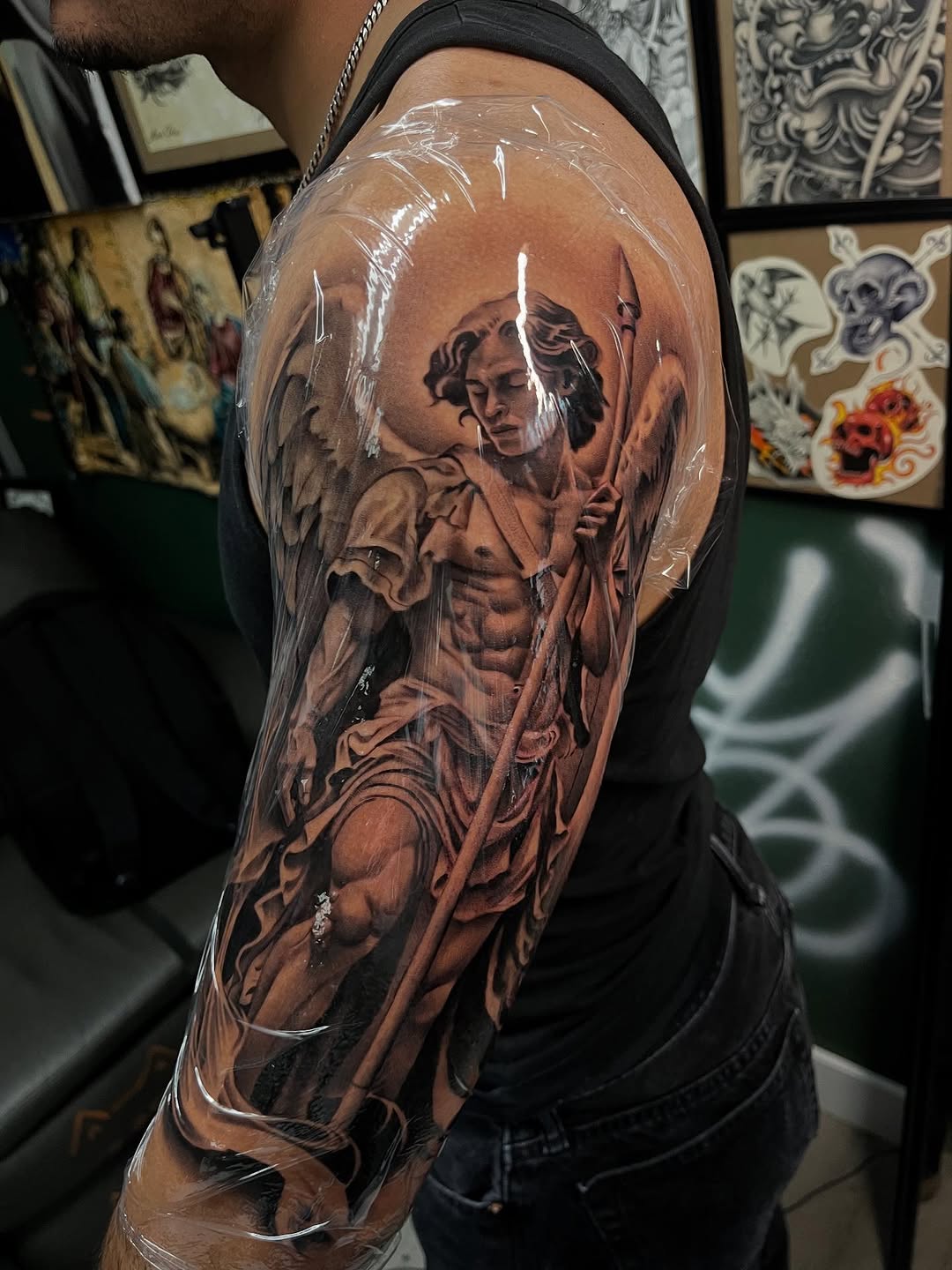 Angel with spear realism tattoo on the upper arm by Denver Tattoo Artist