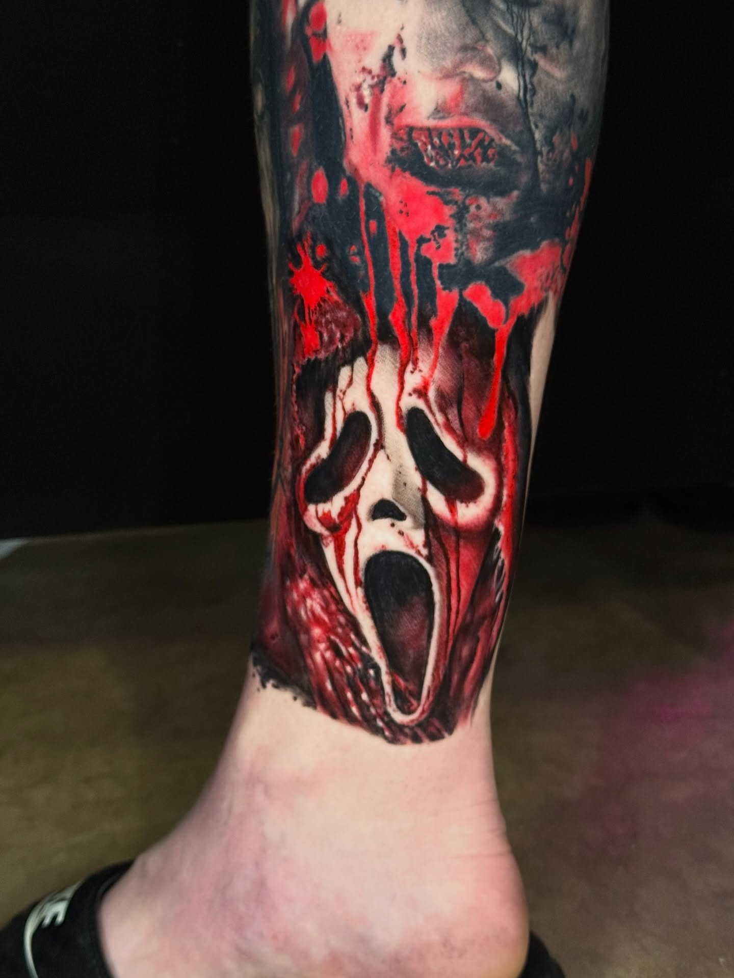 Scream mask realism tattoo on the calf by Sideshow Danny