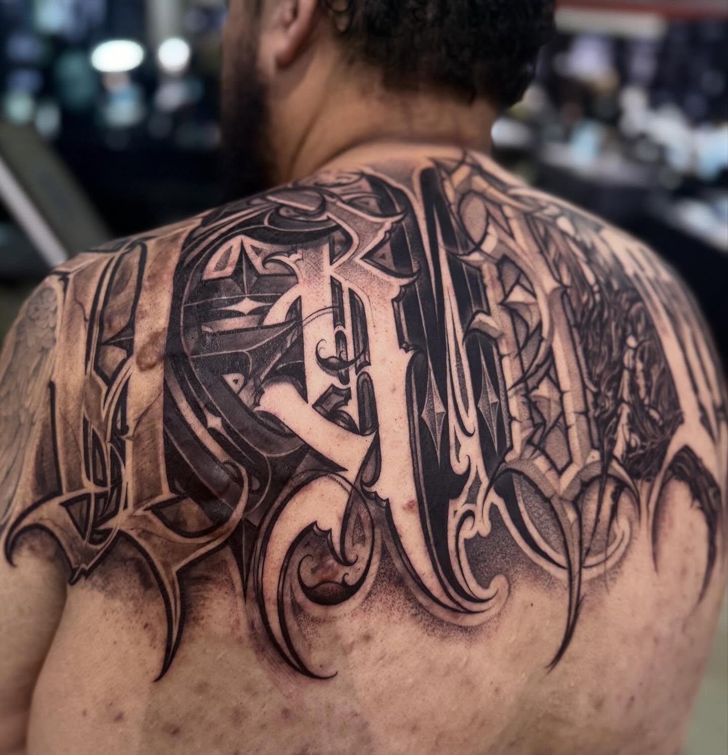 Gothic script geometric tattoo on the back by Ashley brown, Las Vegas, Nevada