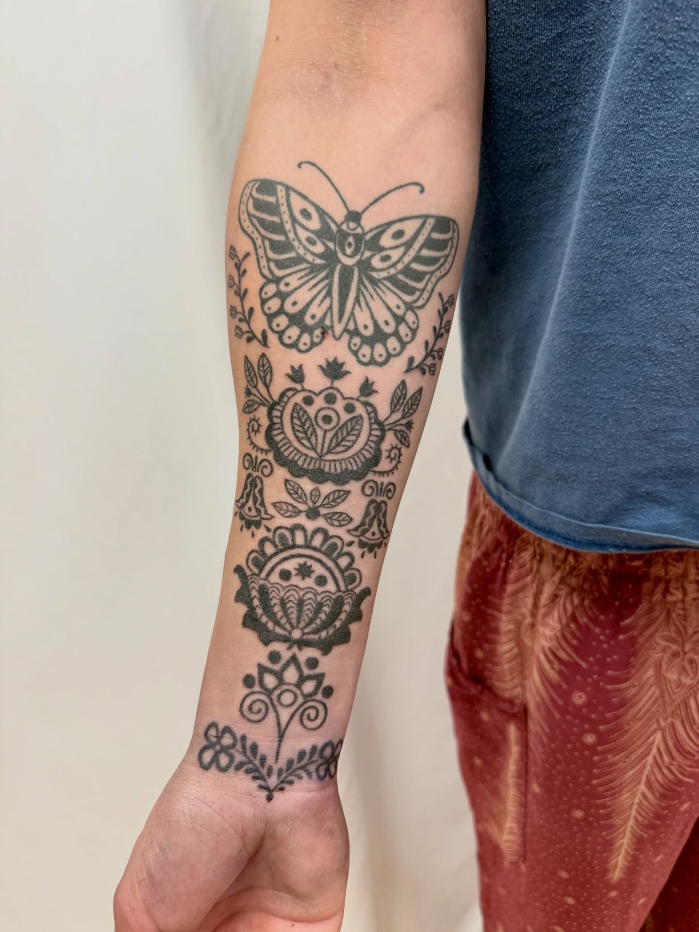 Butterfly and floral black and grey tattoo on the forearm by Melia Mariko