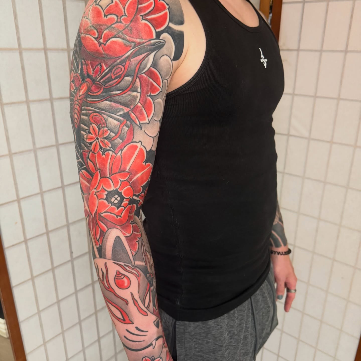 Peony and dragon American traditional tattoo on the upper arm by Dylan