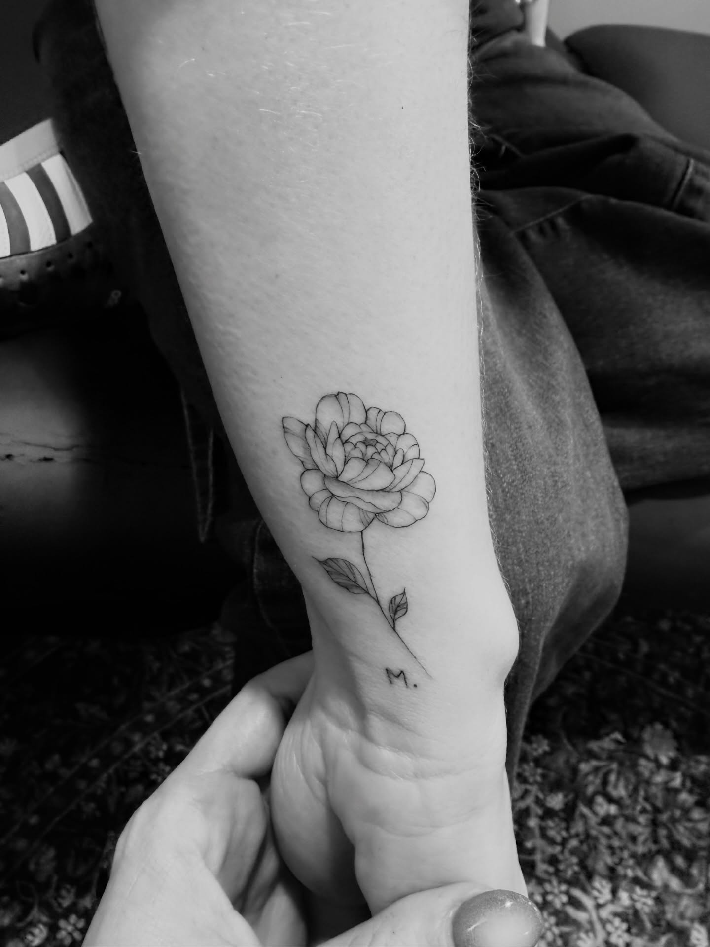 Peony black and grey tattoo on the forearm by Reverie Studio