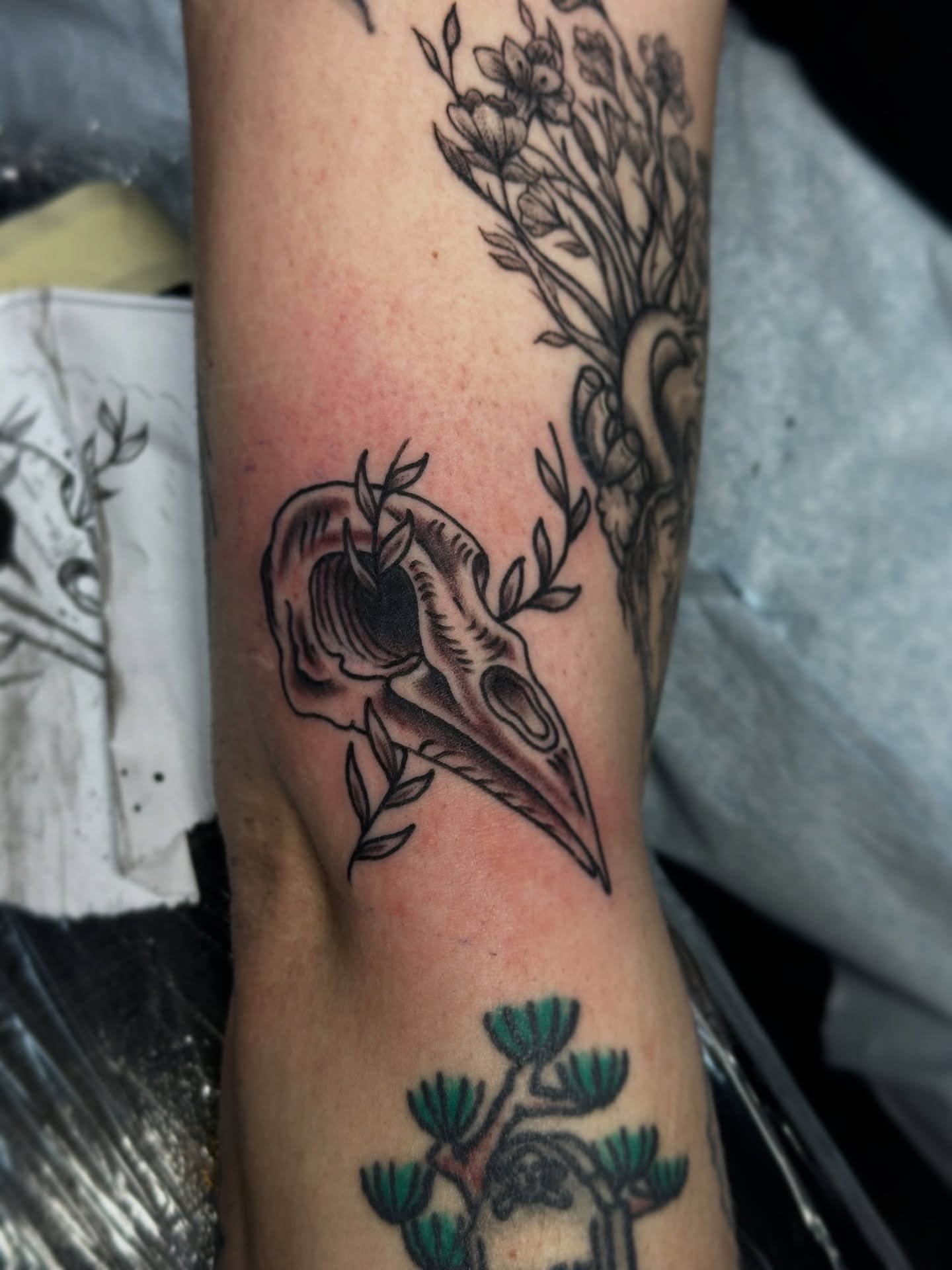 Bird skull and floral arrangement black and grey tattoo on the forearm by 🕸🎚 𝑺𝑨𝑵𝑻𝑰 𝑺𝑬𝑽𝑬𝑵𝑺 🎚🕸🇫🇯