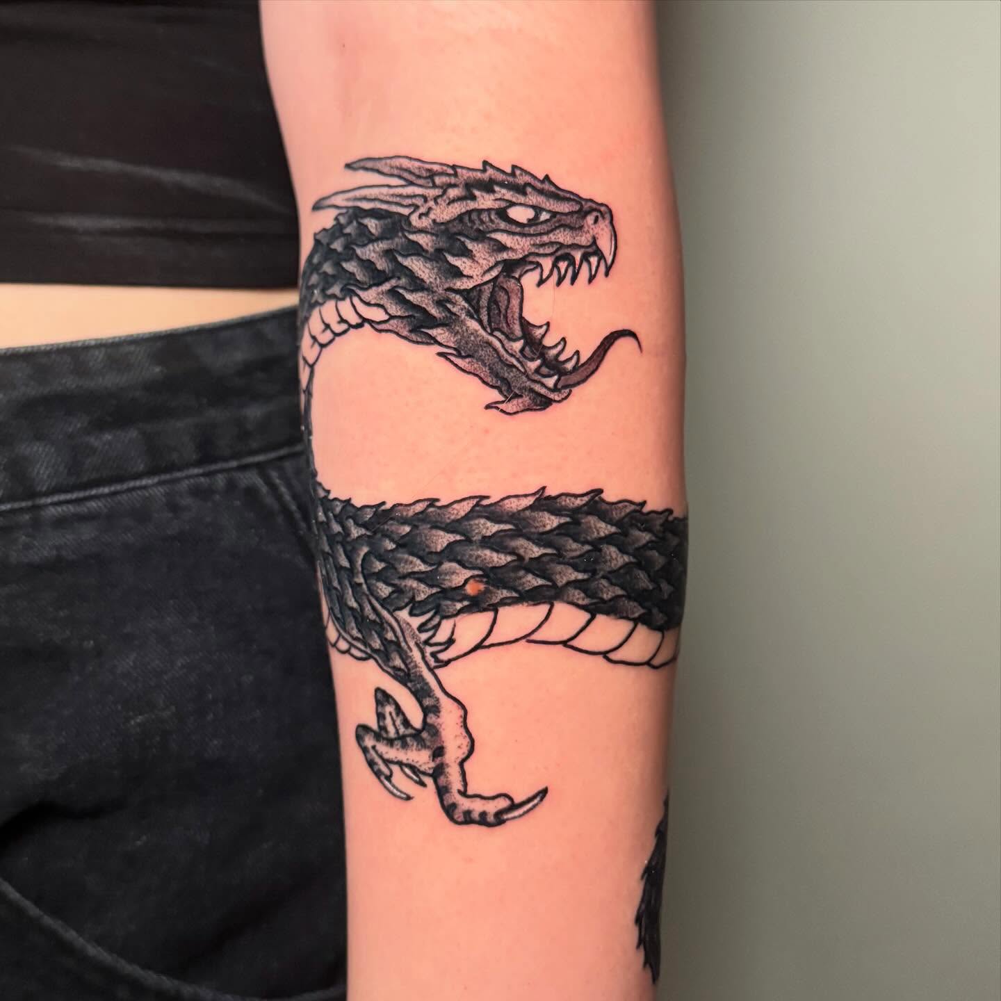 Dragon black and grey tattoo on the forearm by Zac Chaffin