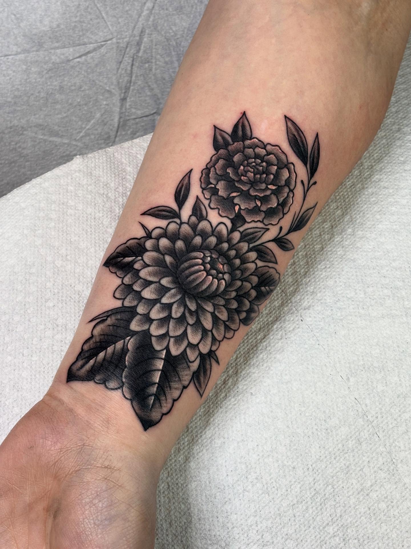 Chrysanthemum and peony black and grey tattoo on the forearm by Mike DiCicco