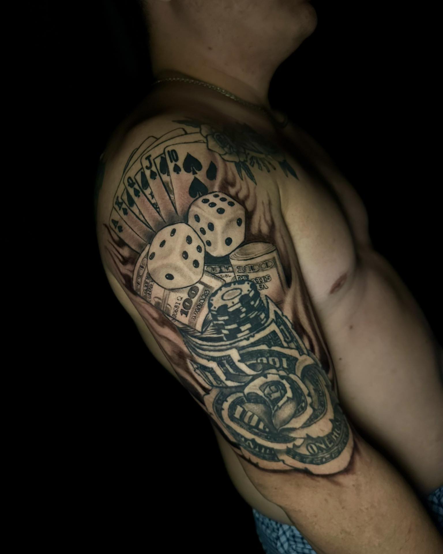 Cards, dice, money, chips realism tattoo on the shoulder by Stephen Degracia
