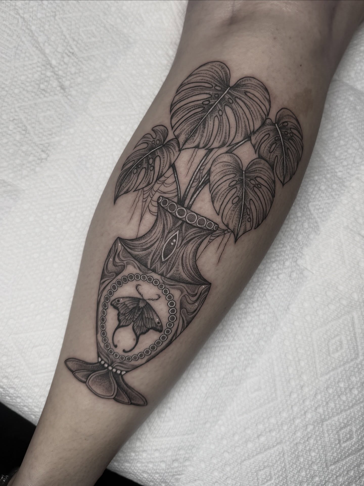 Monstera leaves and butterfly geometric tattoo on the forearm by Mara Flores βπΛβ§