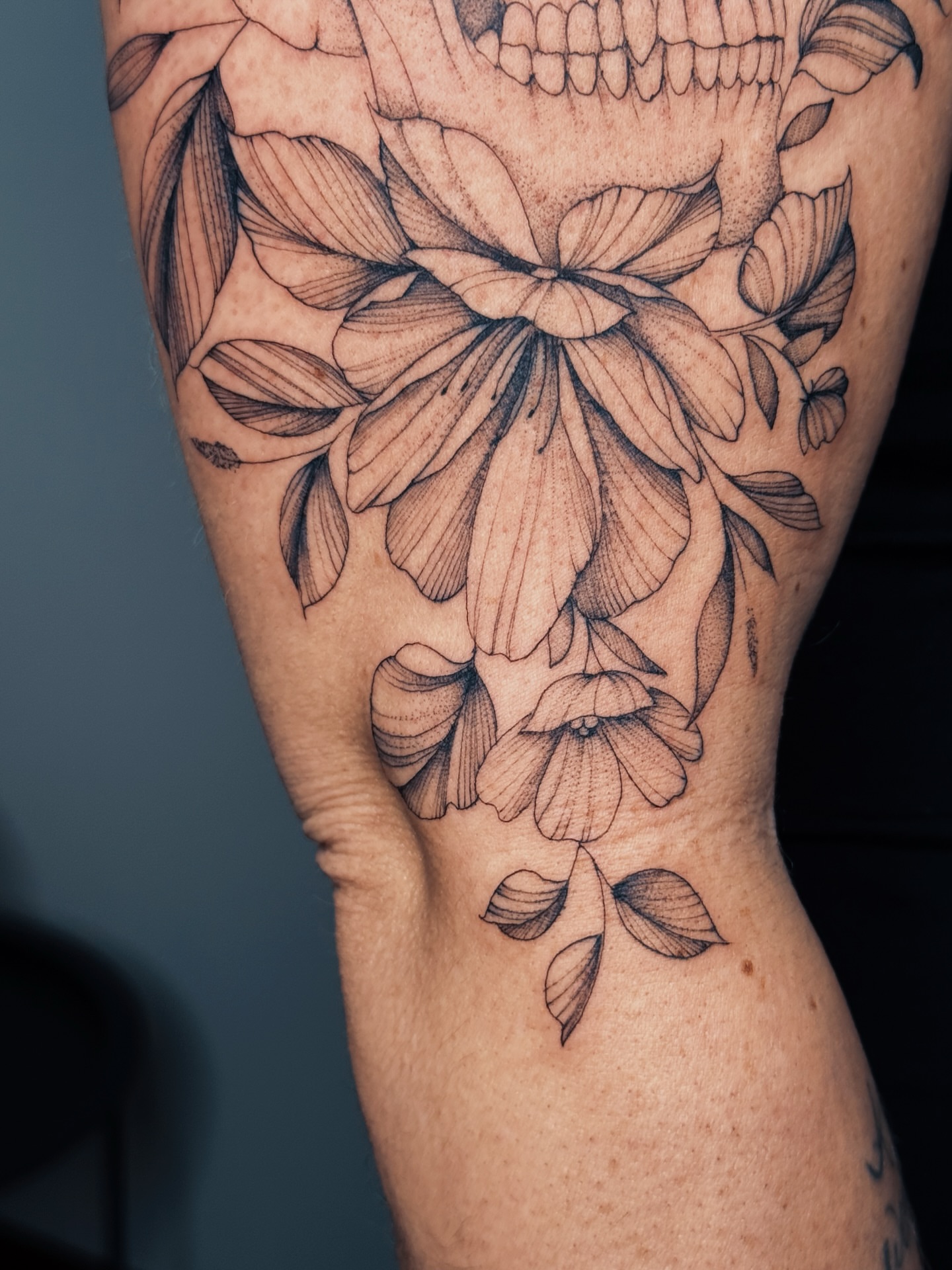 Floral arrangement black and grey tattoo on the forearm by Olha Tytarenko