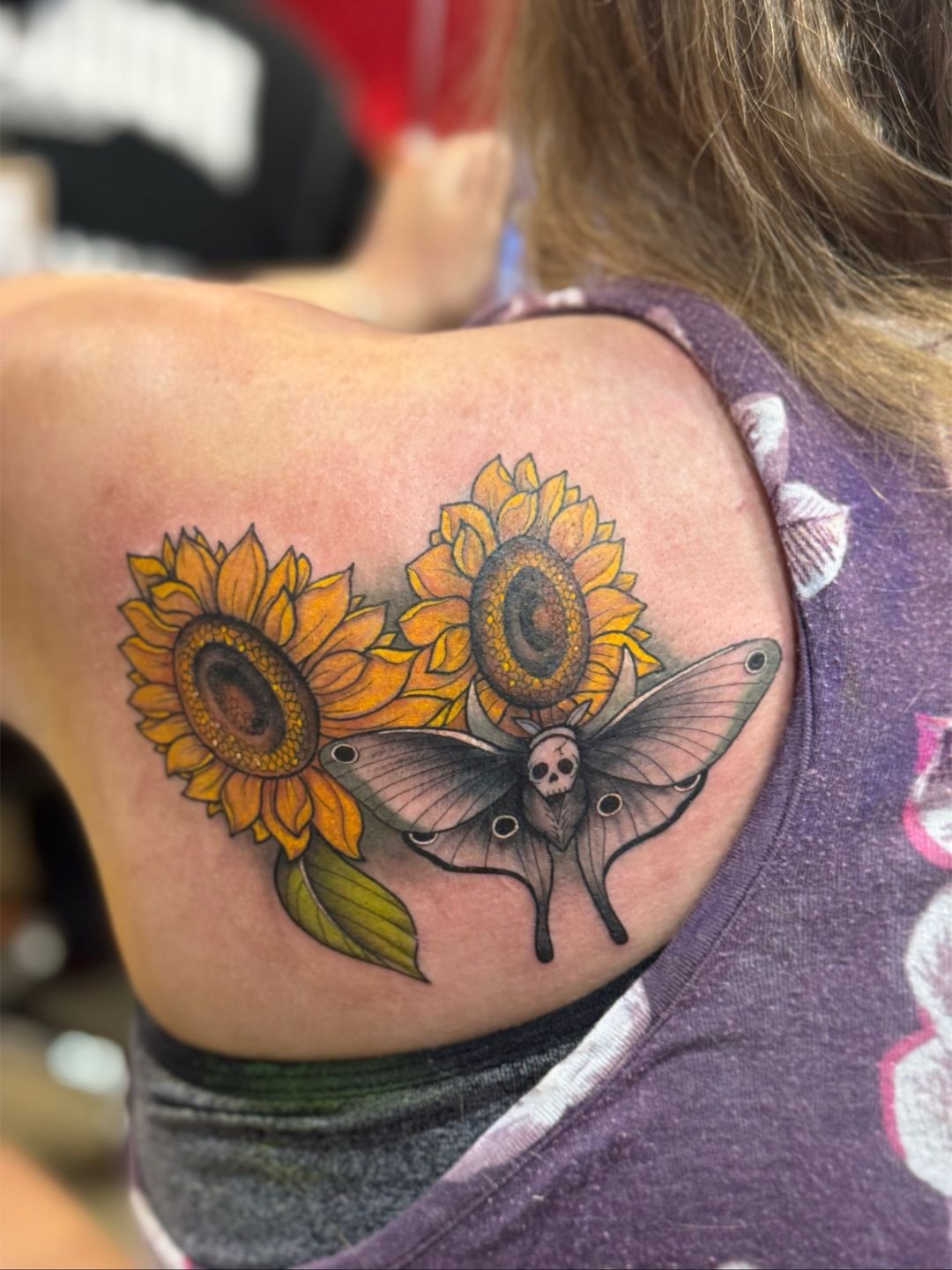 Sunflowers and moth realism tattoo on the shoulder by North County Sd