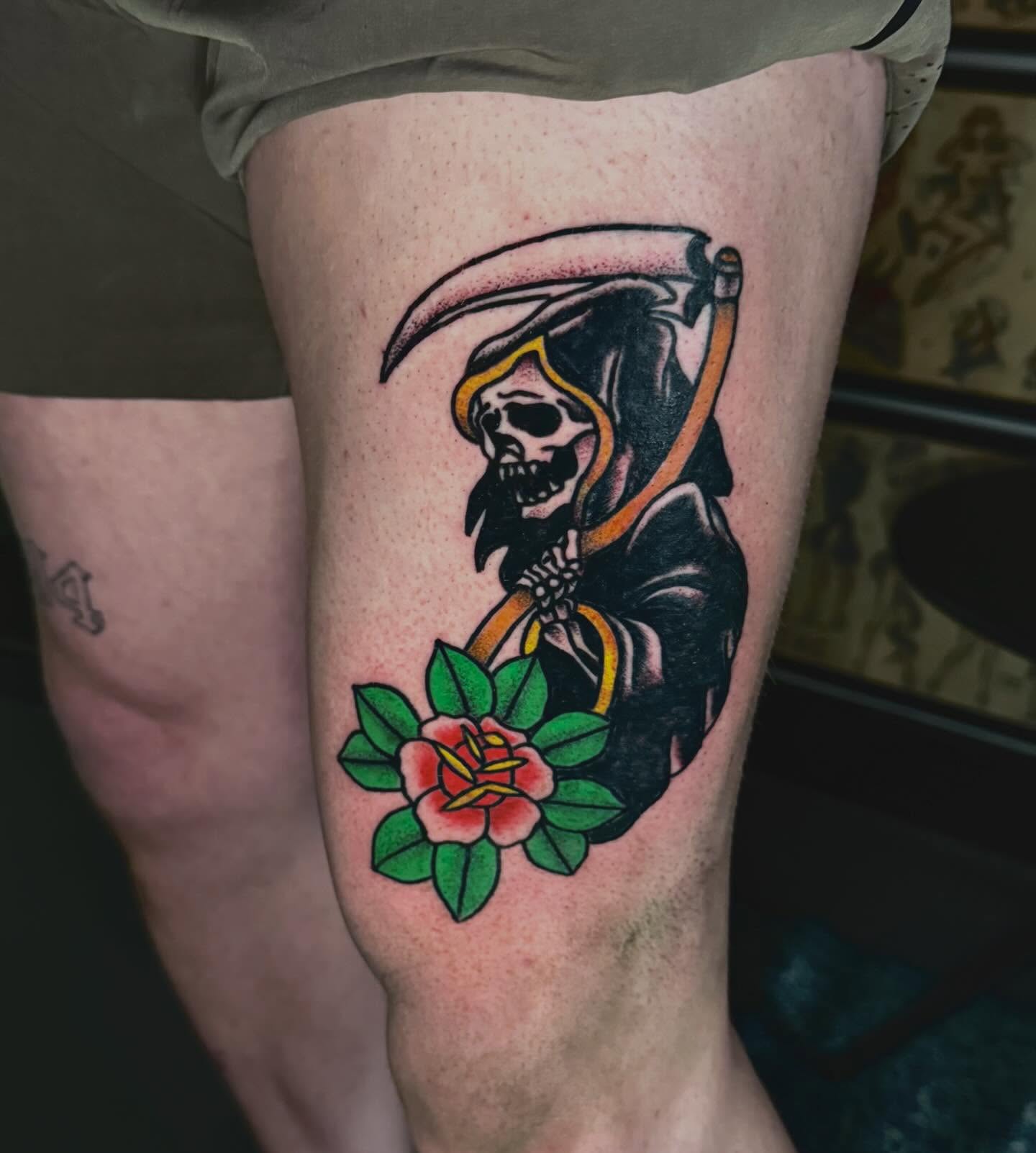 Grim reaper with flower American traditional tattoo on the thigh by Mason McCubbin