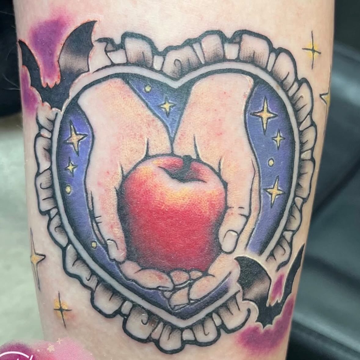 Hands holding apple American traditional tattoo on the forearm by Chloe ‘baby’ Martin