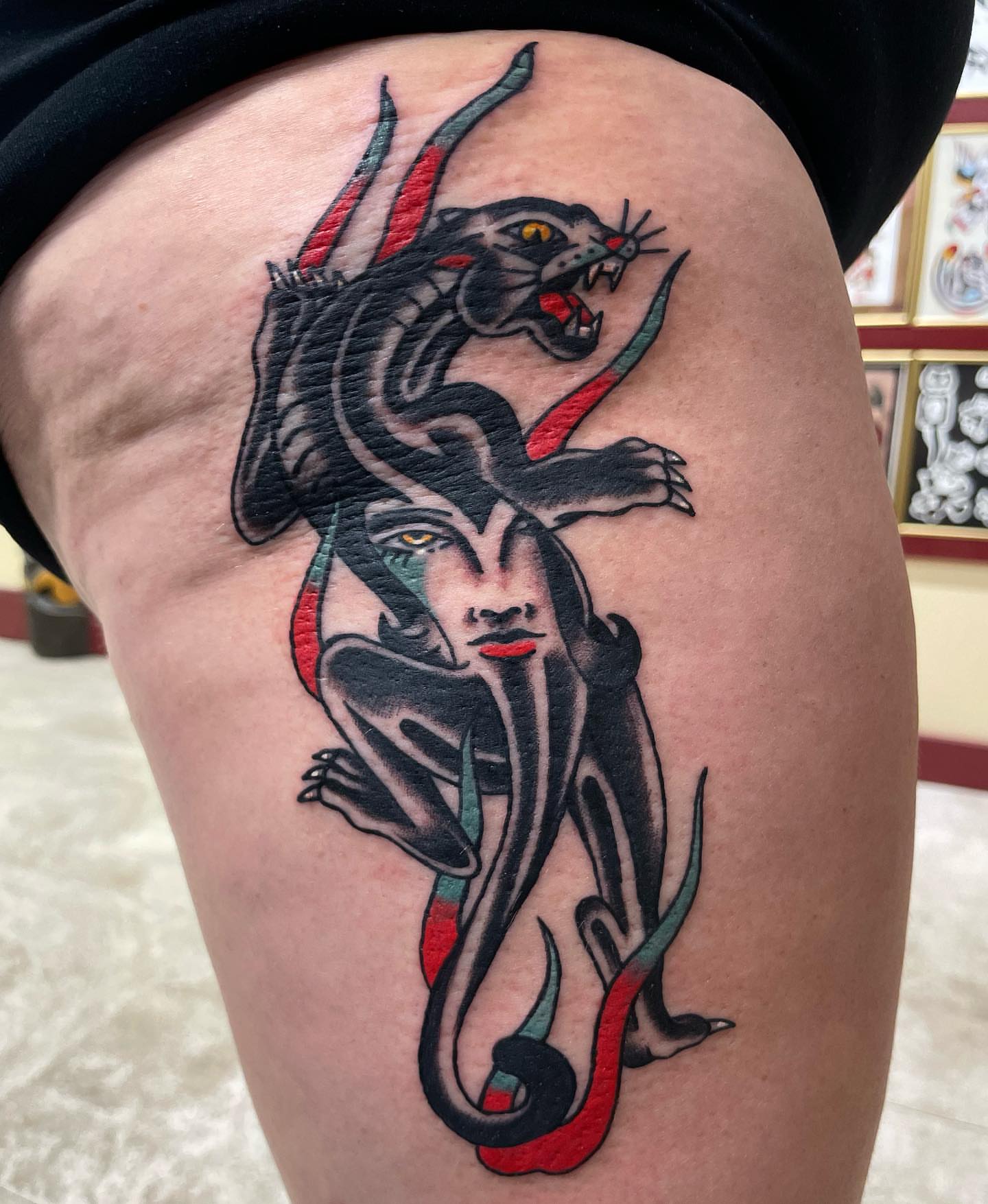 Woman with snake American traditional tattoo on the thigh by Gerald Bellmore