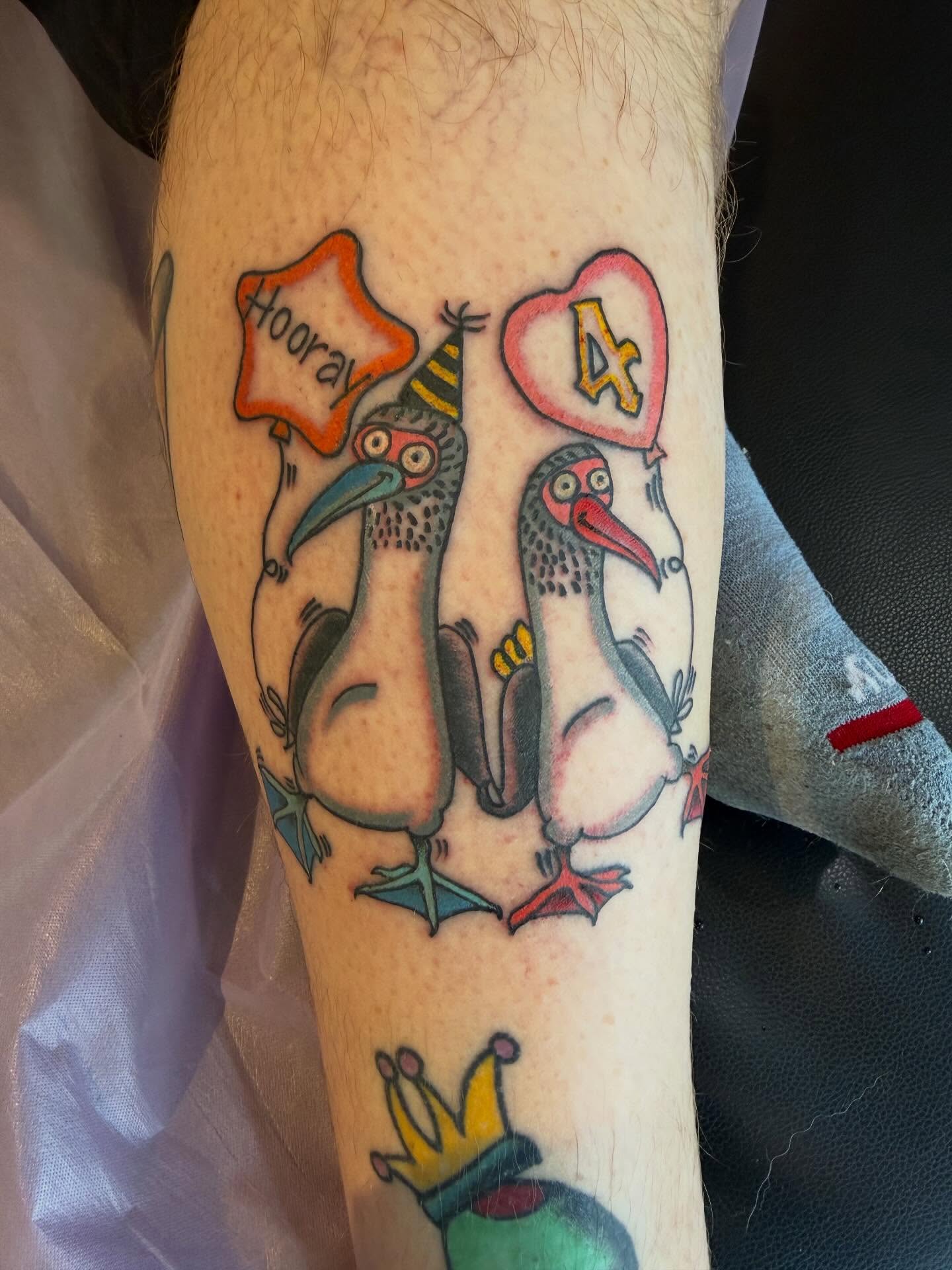 Storks with party hats American traditional tattoo on the forearm by Mike Kepper