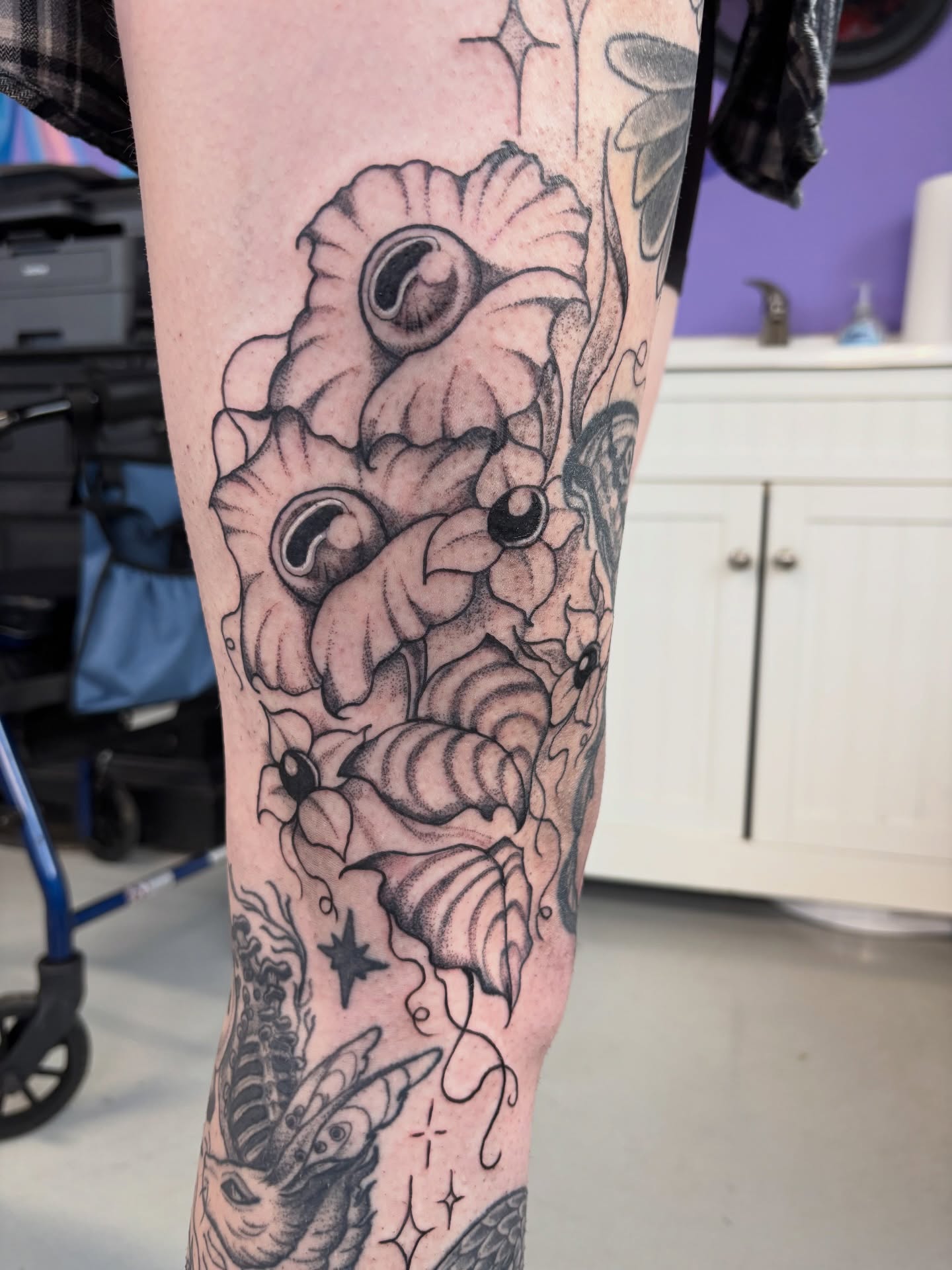 Flowers and leaves black and grey tattoo on the leg by Nashville Tattoo Artist