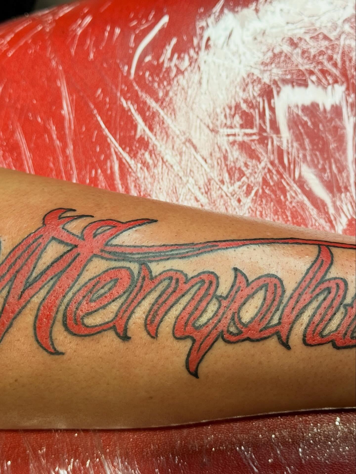 Memphis lettering script tattoo on the forearm by Jones Eric