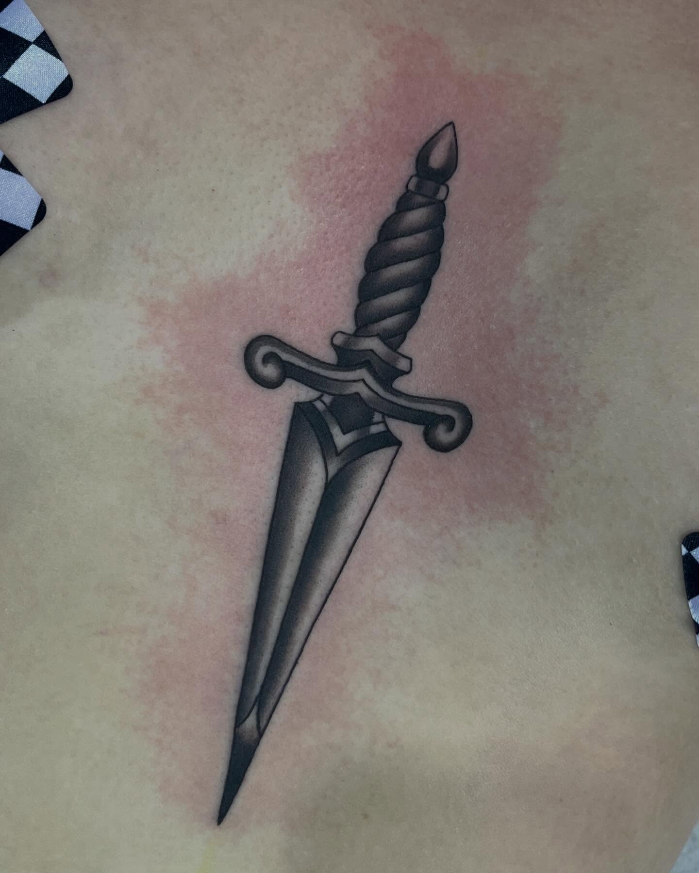 Dagger black and grey tattoo on the chest by Taylor Santavicca