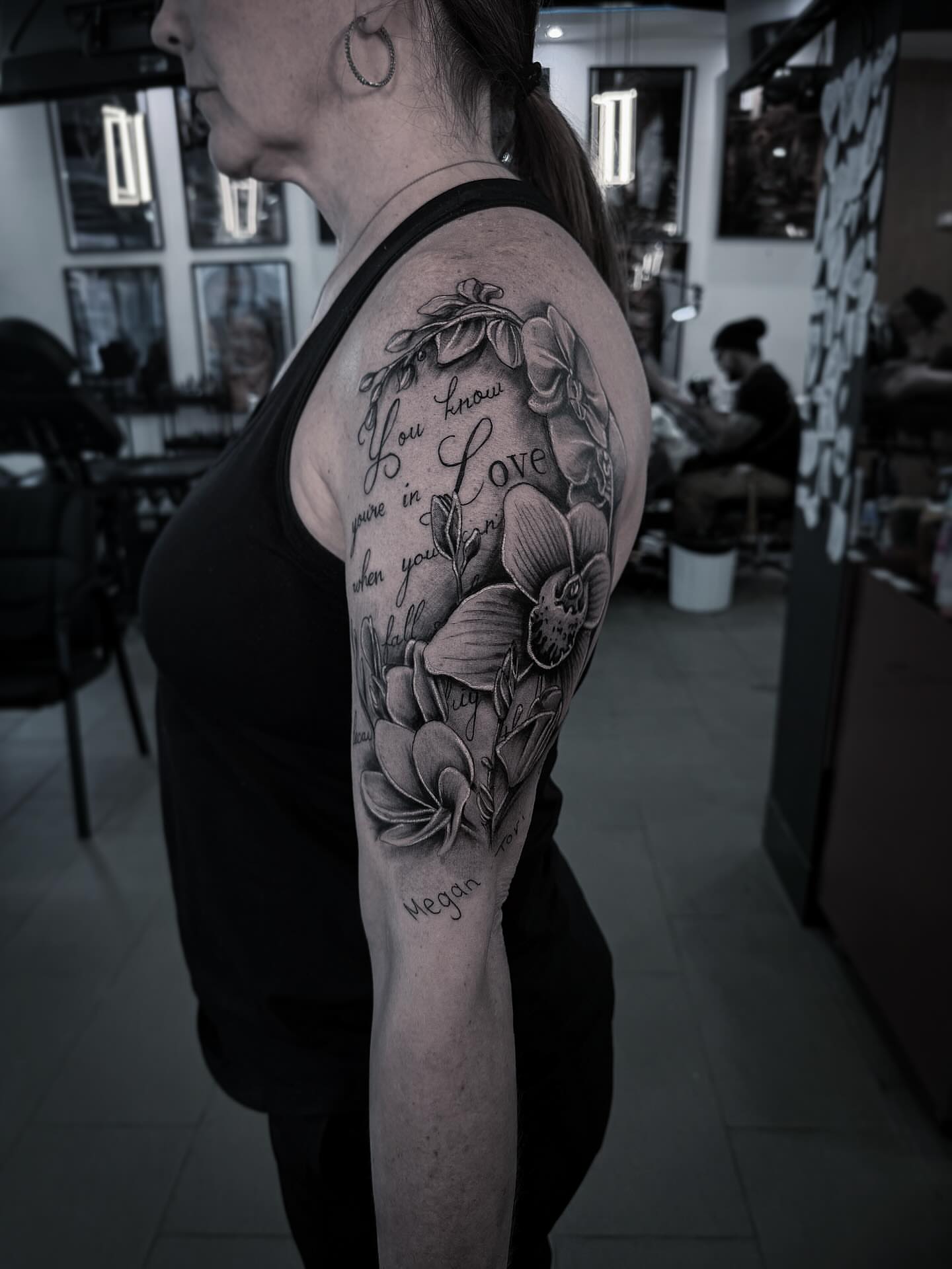 Orchid and script realism tattoo on the upper arm by Tattoo Ottawa