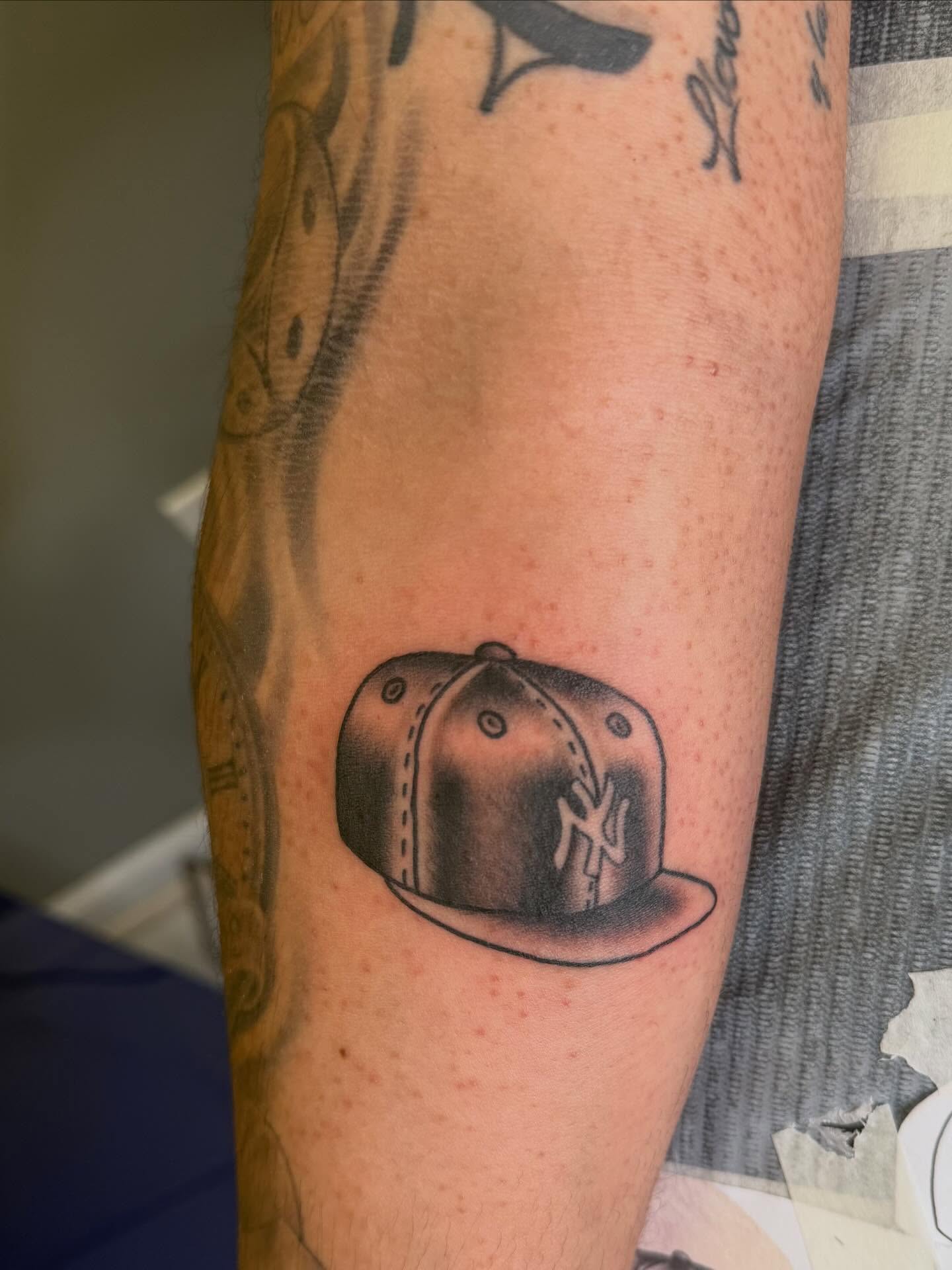 Ny yankees cap black and grey tattoo on the forearm by linda perez
