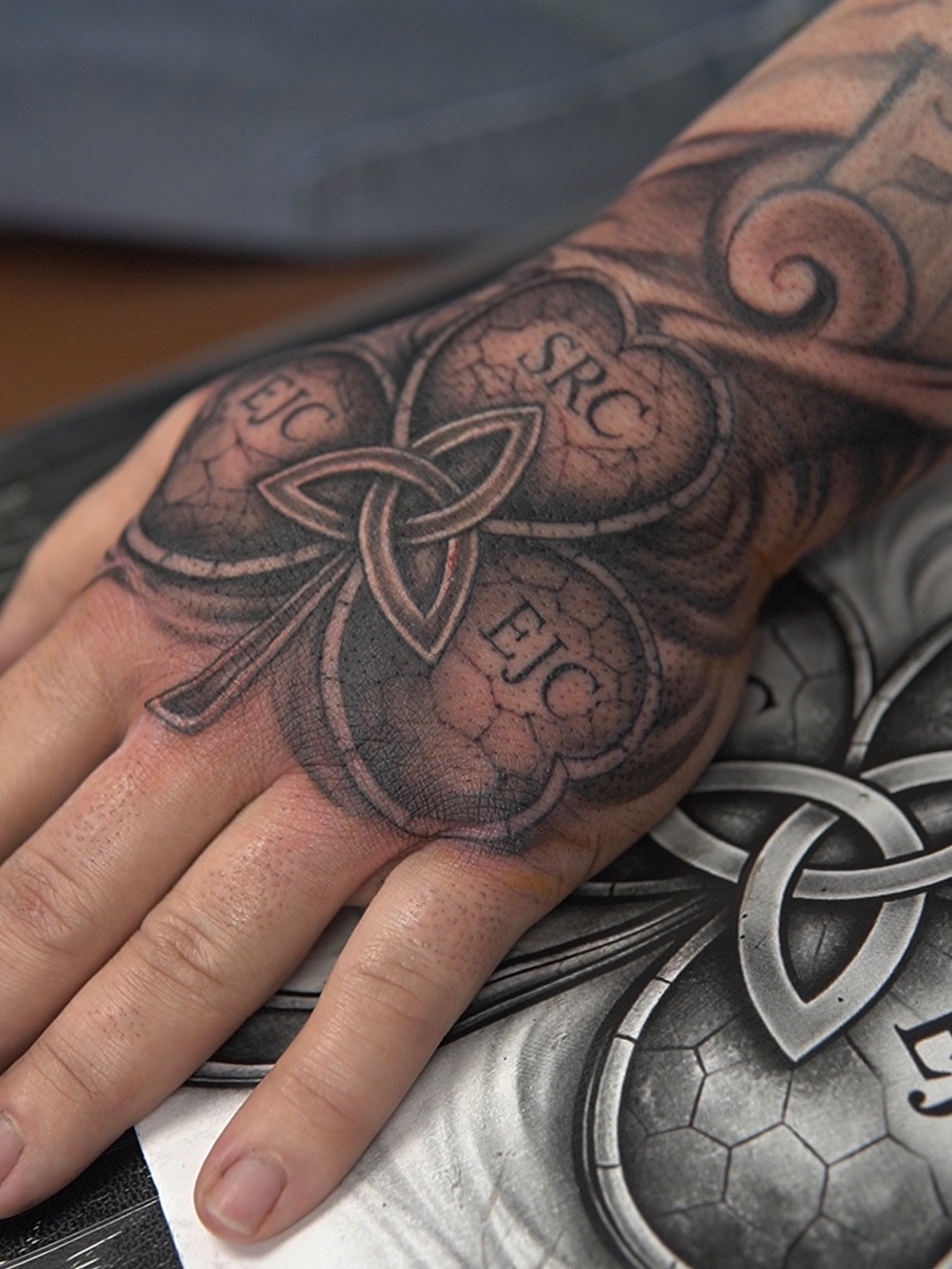 Trinity knot black and grey tattoo on the hand by Sebastian