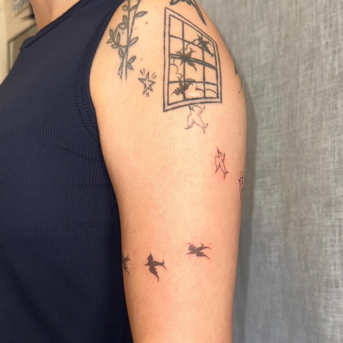 Window with birds black and grey tattoo on the upper arm by kate