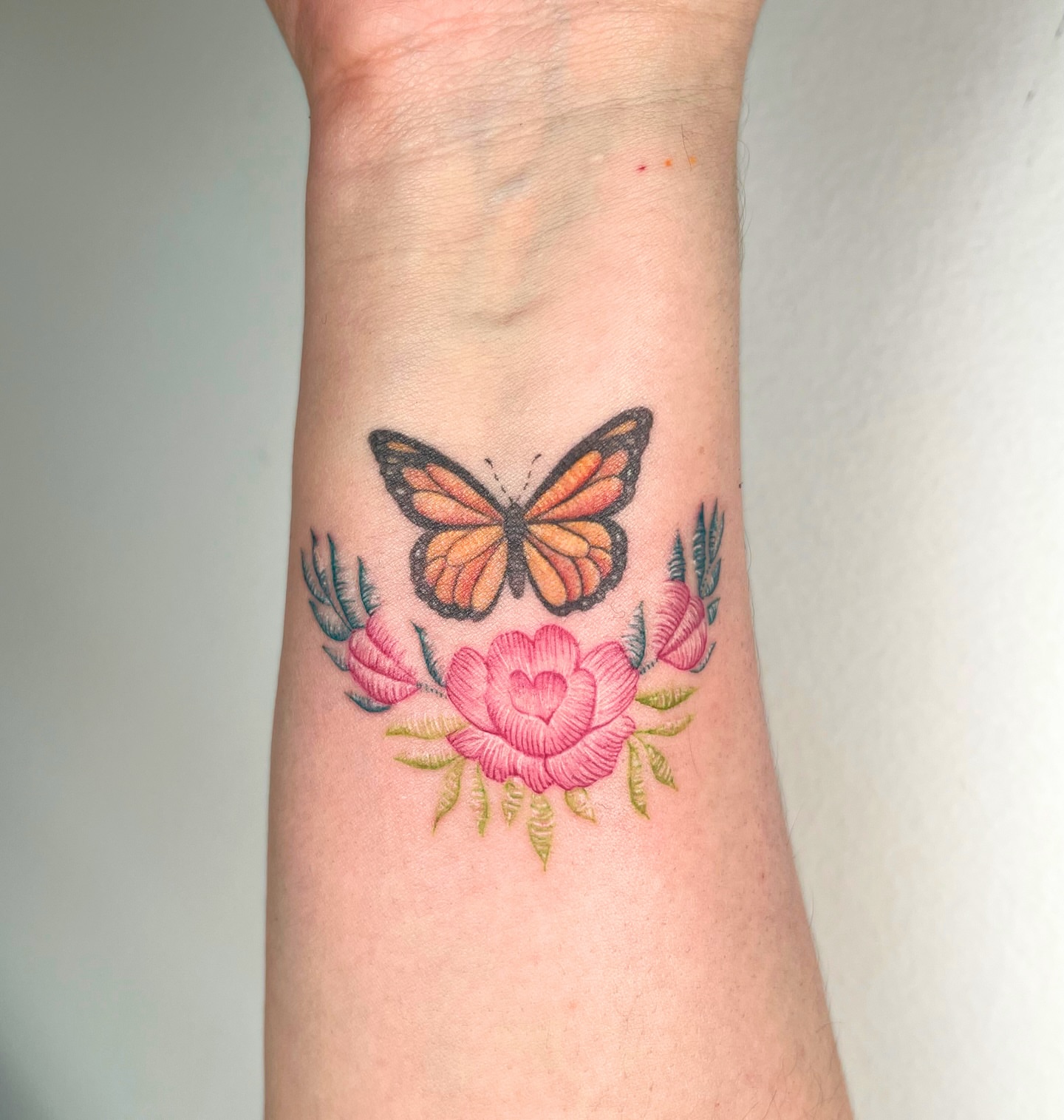 Butterfly and flowers new school tattoo on the forearm by kt