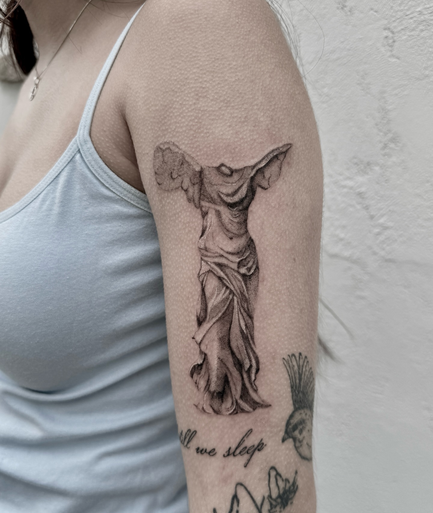 Statue of a winged figure realism tattoo on the forearm by Raleigh tattoo artist, Raleigh, North Carolina