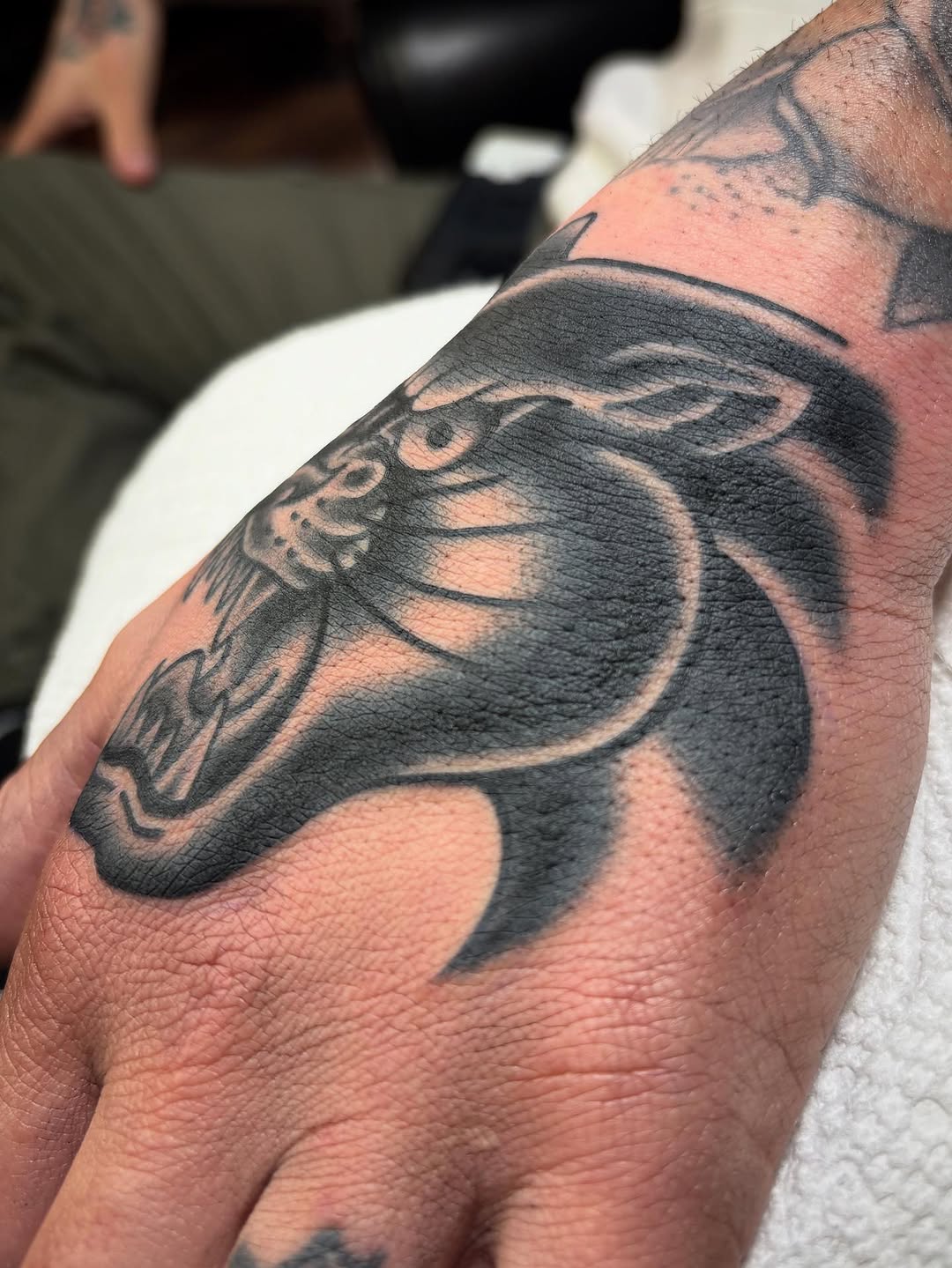 Panther head realism tattoo on the forearm by Tom Wenzell