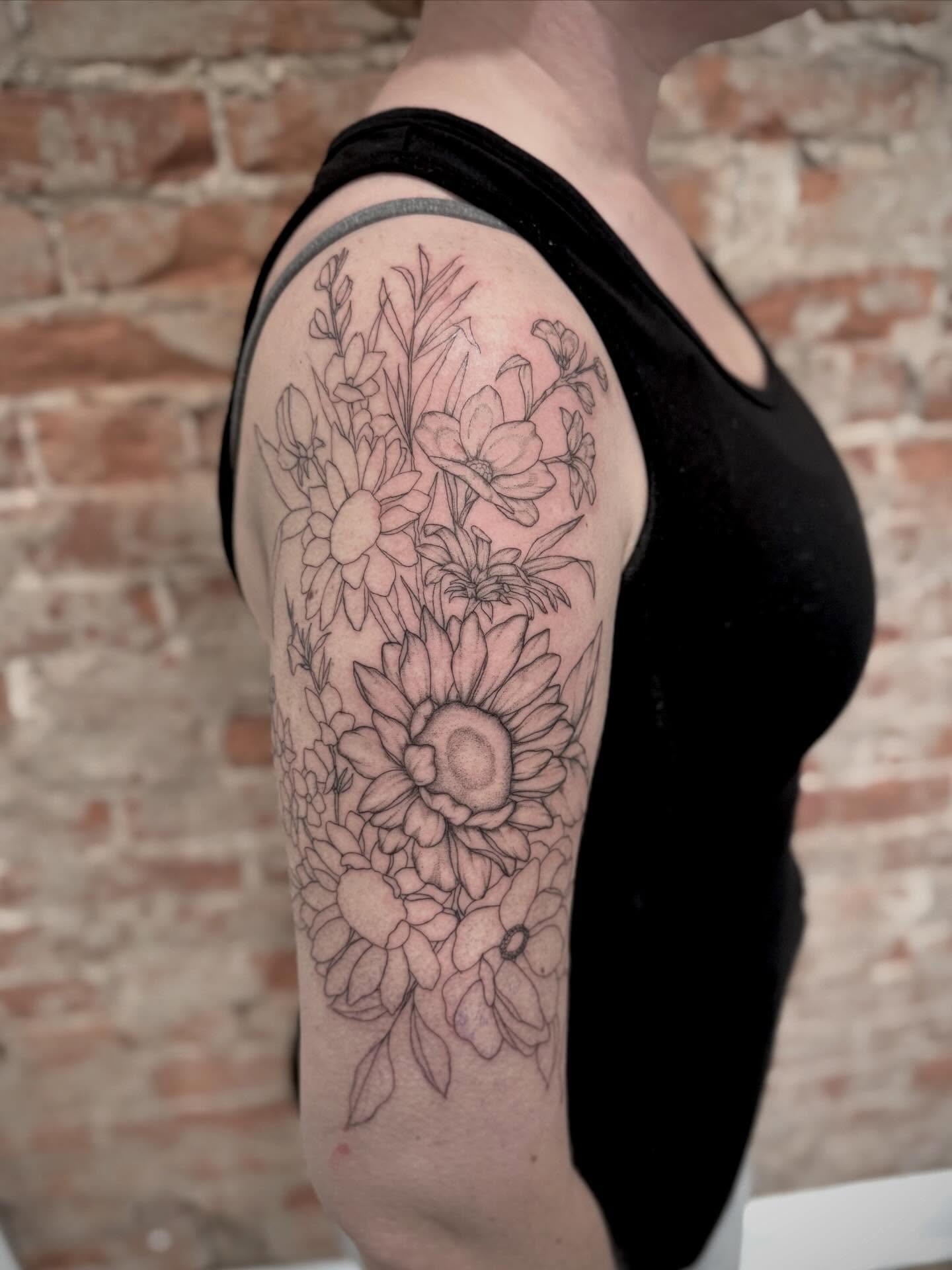 Flower bouquet black and grey tattoo on the upper arm by Daniel Anthony, Philadelphia, Pennsylvania