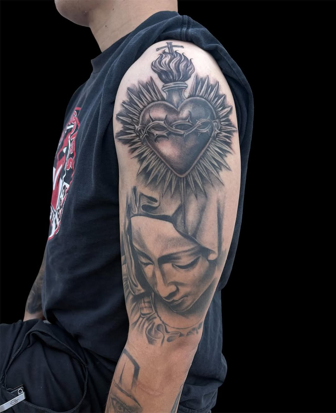 Sacred Heart and Virgin Mary Chicano tattoo on the upper arm by @inkwitatlas