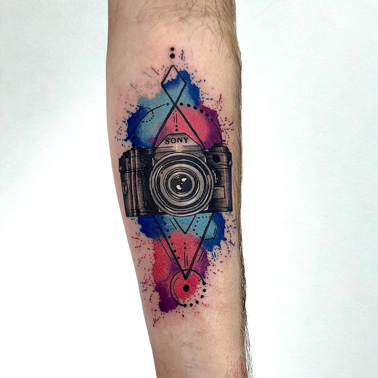 Camera watercolor tattoo on the forearm by Abby Ash, Belington, West Virginia