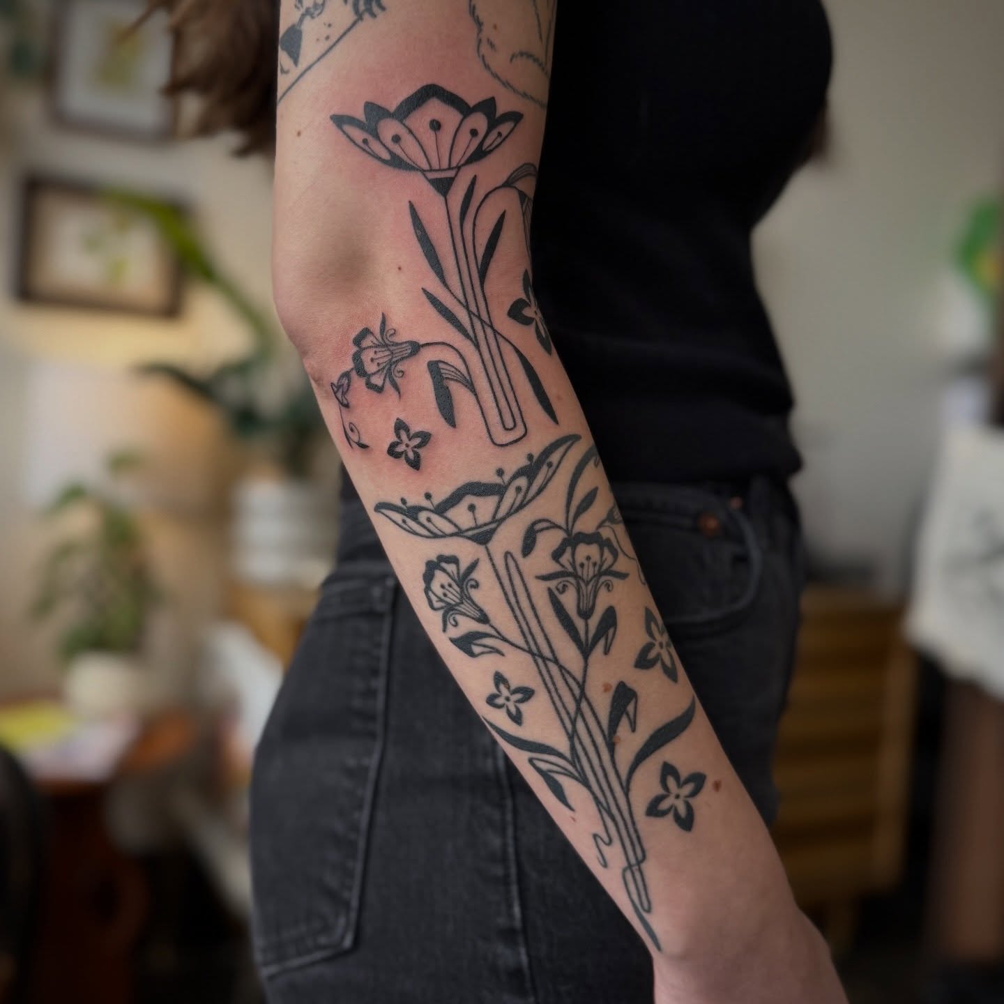 Floral arrangement black and grey tattoo on the forearm by Leah - Tattoo Artist