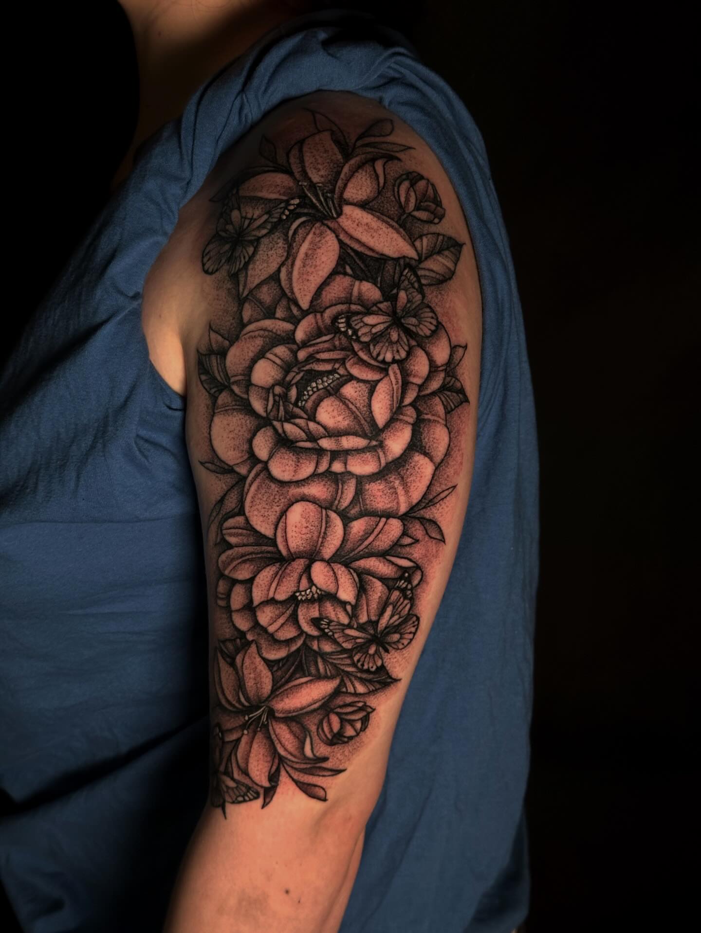 Flowers black and grey tattoo on the upper arm by Elizabeth Tabler
