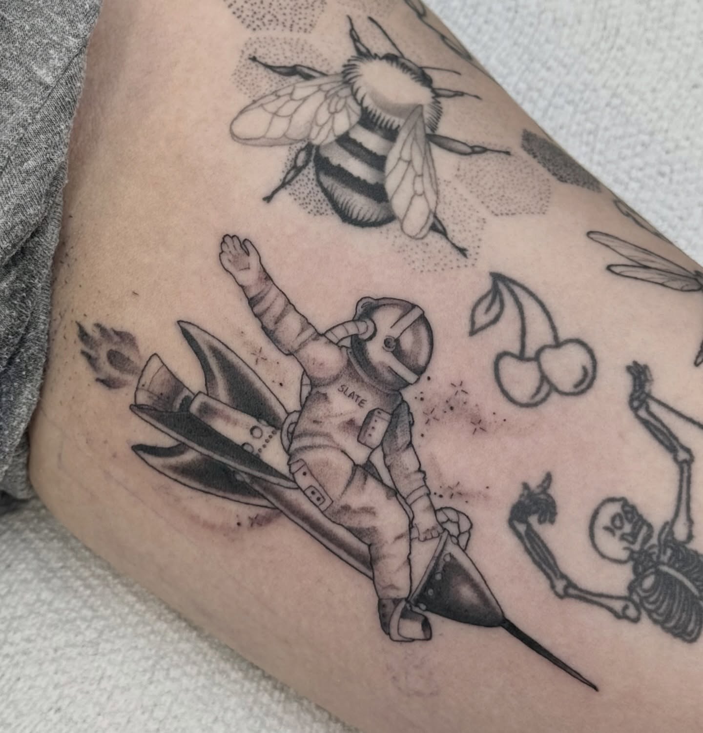 Astronaut black and grey tattoo on the forearm by autumn sky