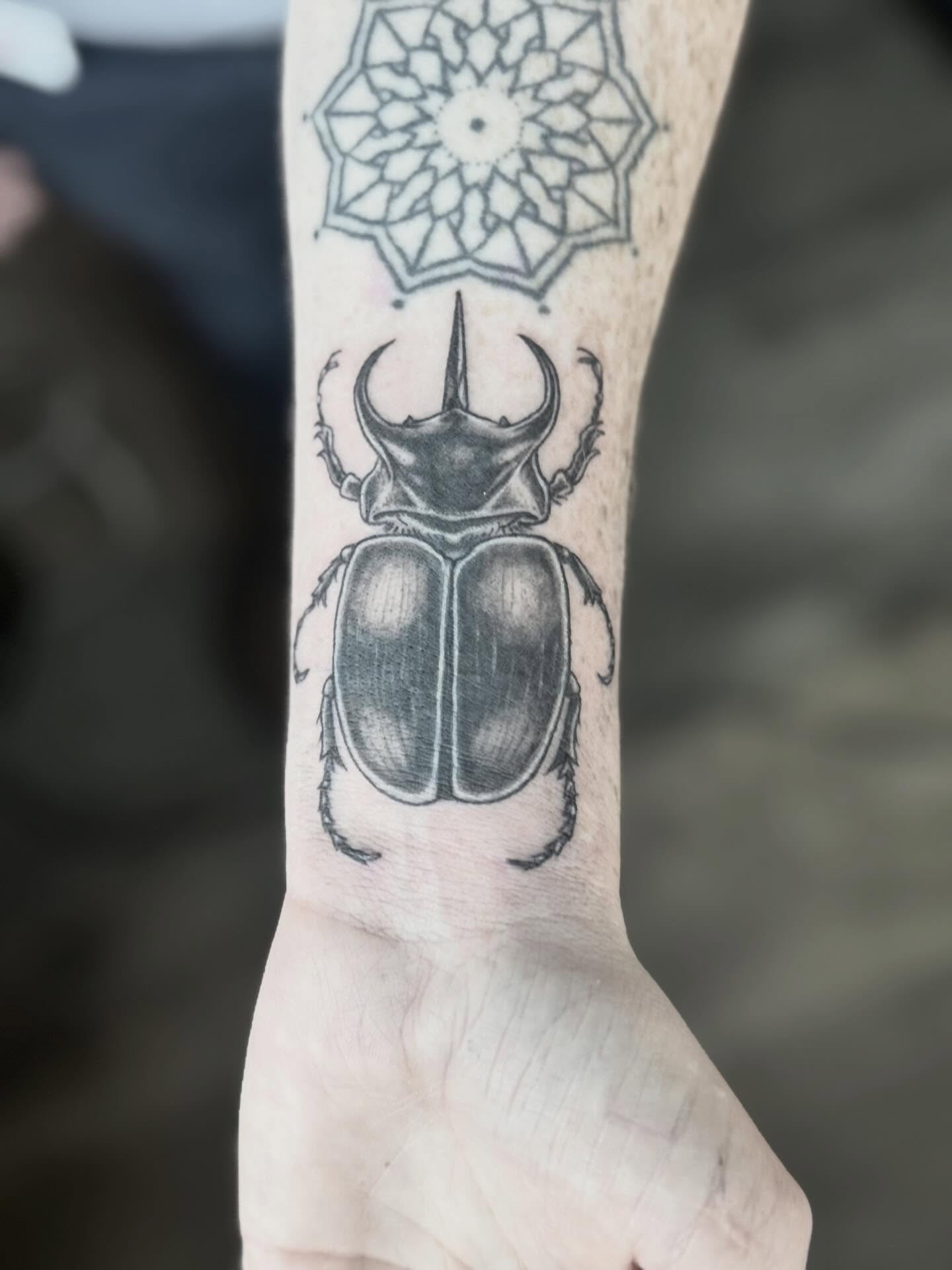 Scarab beetle black and grey tattoo on the forearm by @carissaetattoos