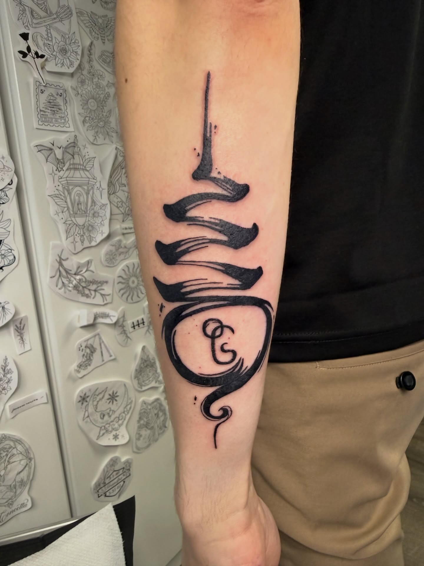 Abstract swirl black and grey tattoo on the forearm by Alexx Colombo