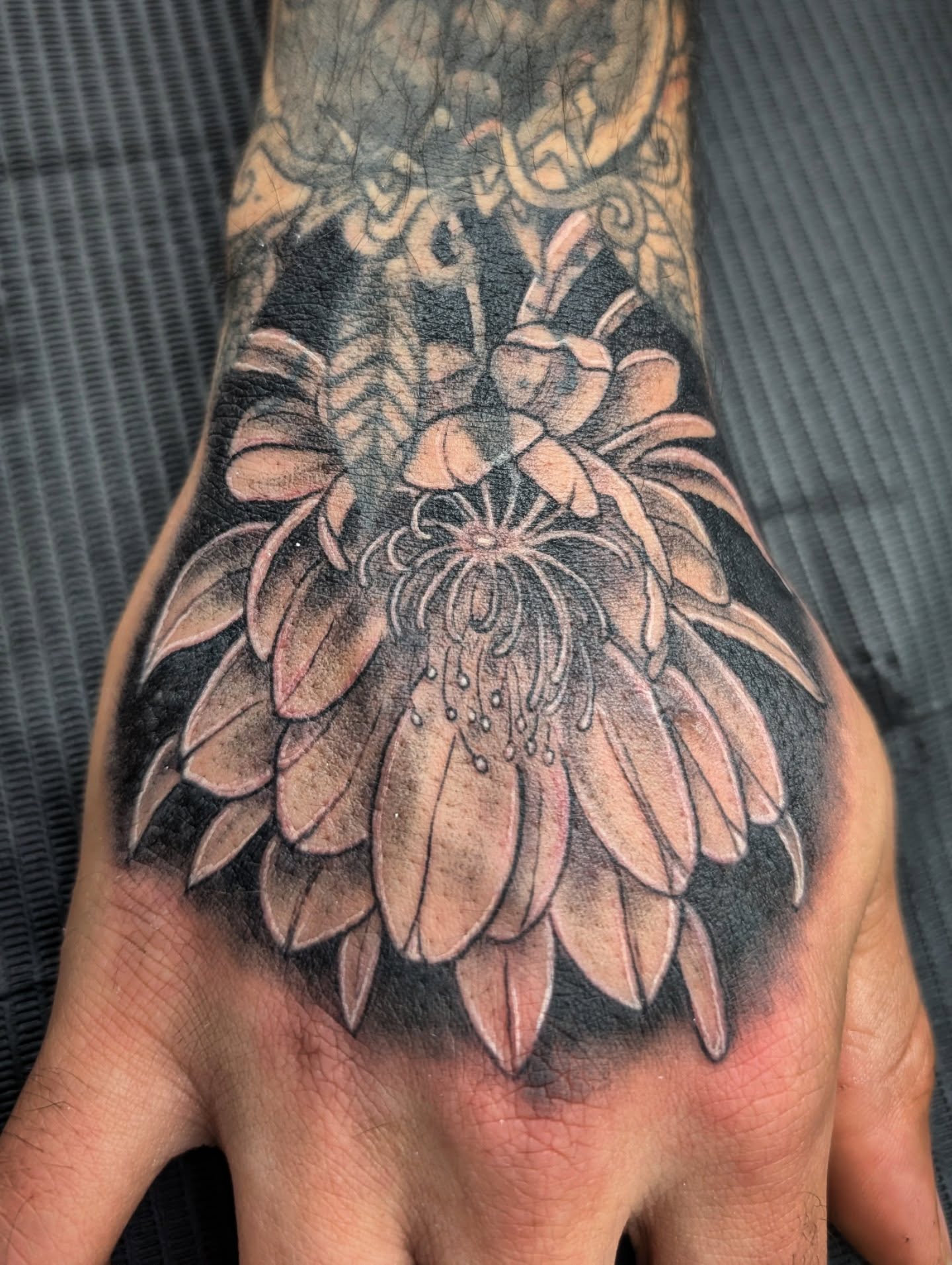 Chrysanthemum black and grey tattoo on the hand by Katherine