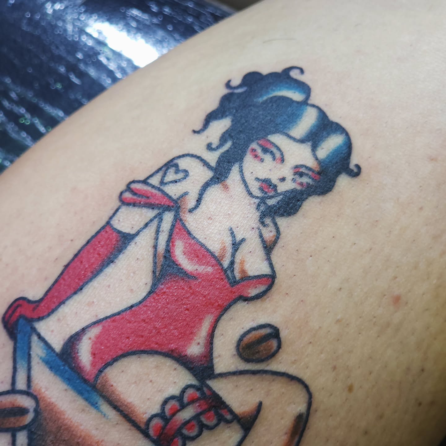 Pin-up girl American traditional tattoo on the thigh by Maxine Stewart