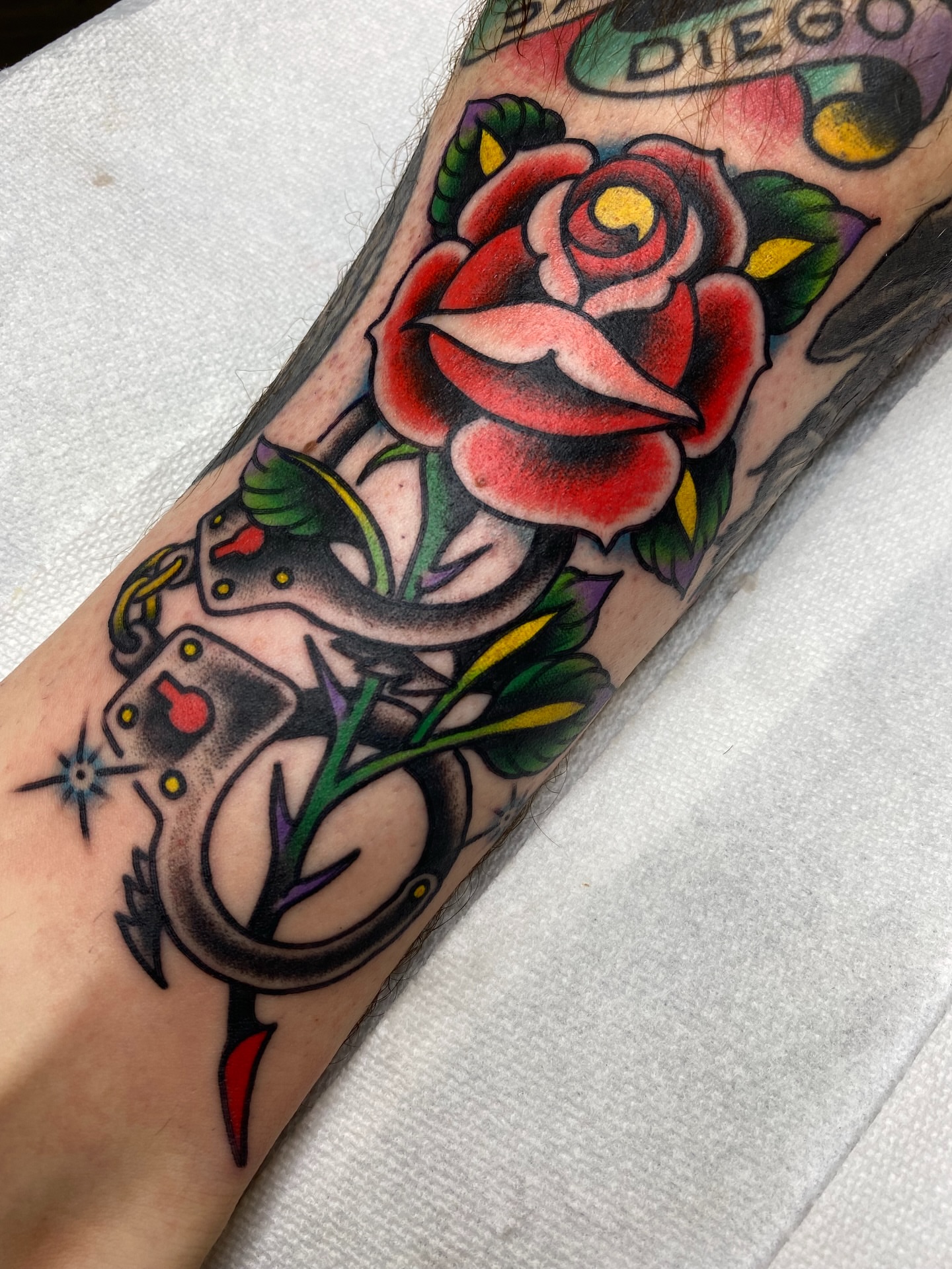 Rose and snake American traditional tattoo on the forearm by Ben Karnofsky