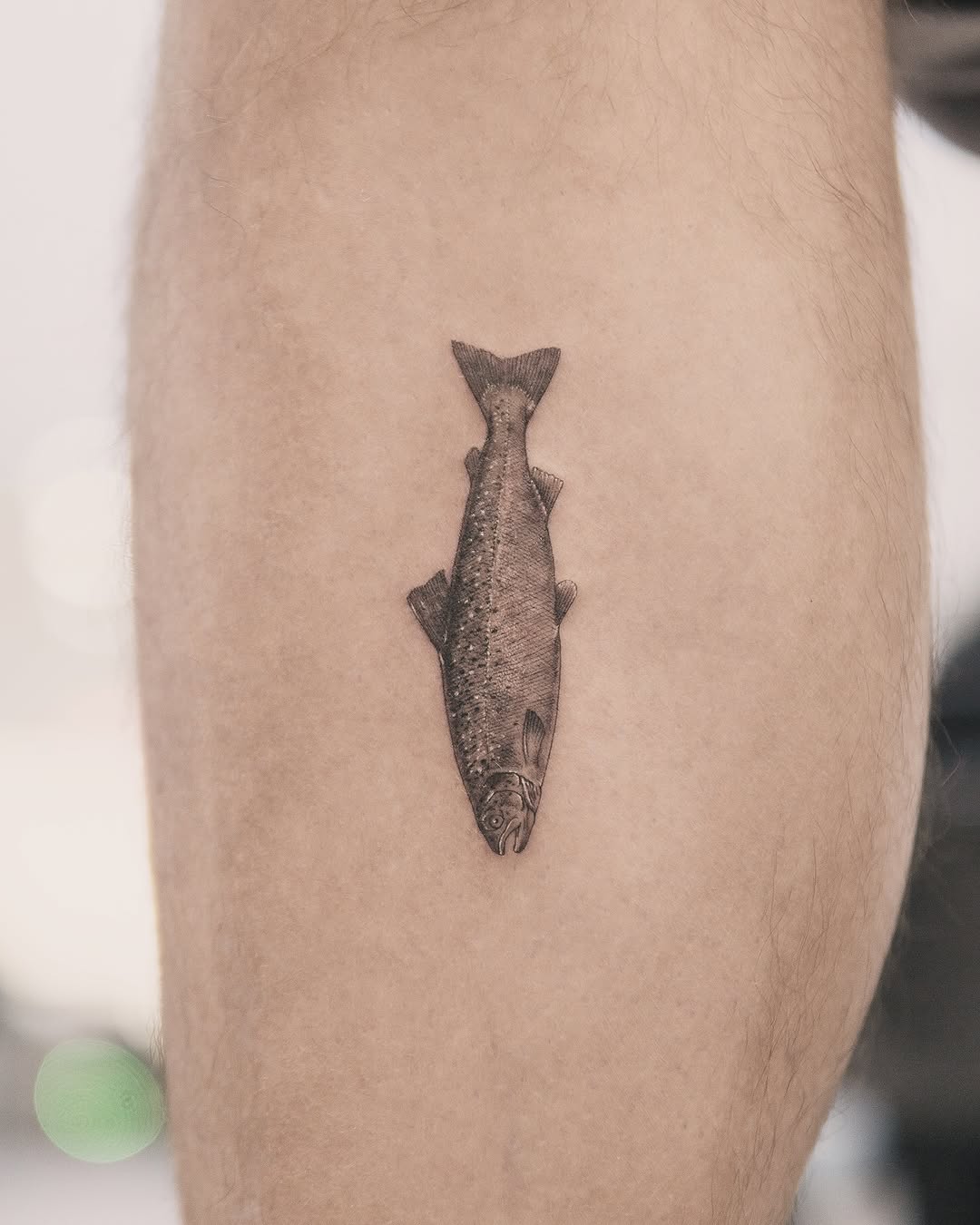 Fish fine line tattoo on the leg by Joey