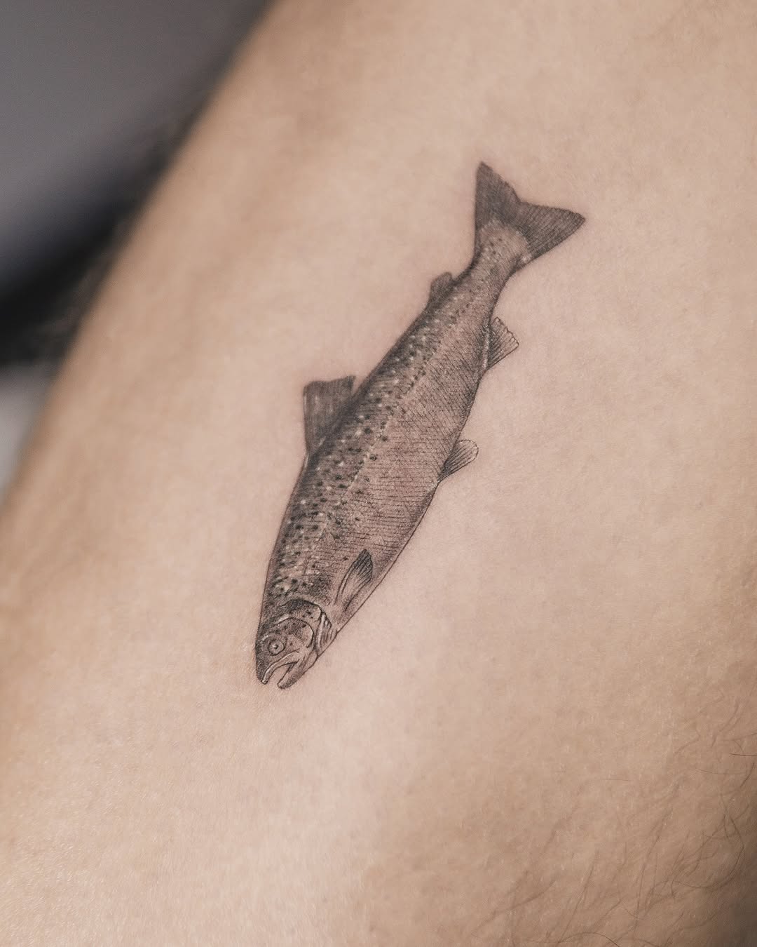 Fish fine line tattoo on the forearm by Joey