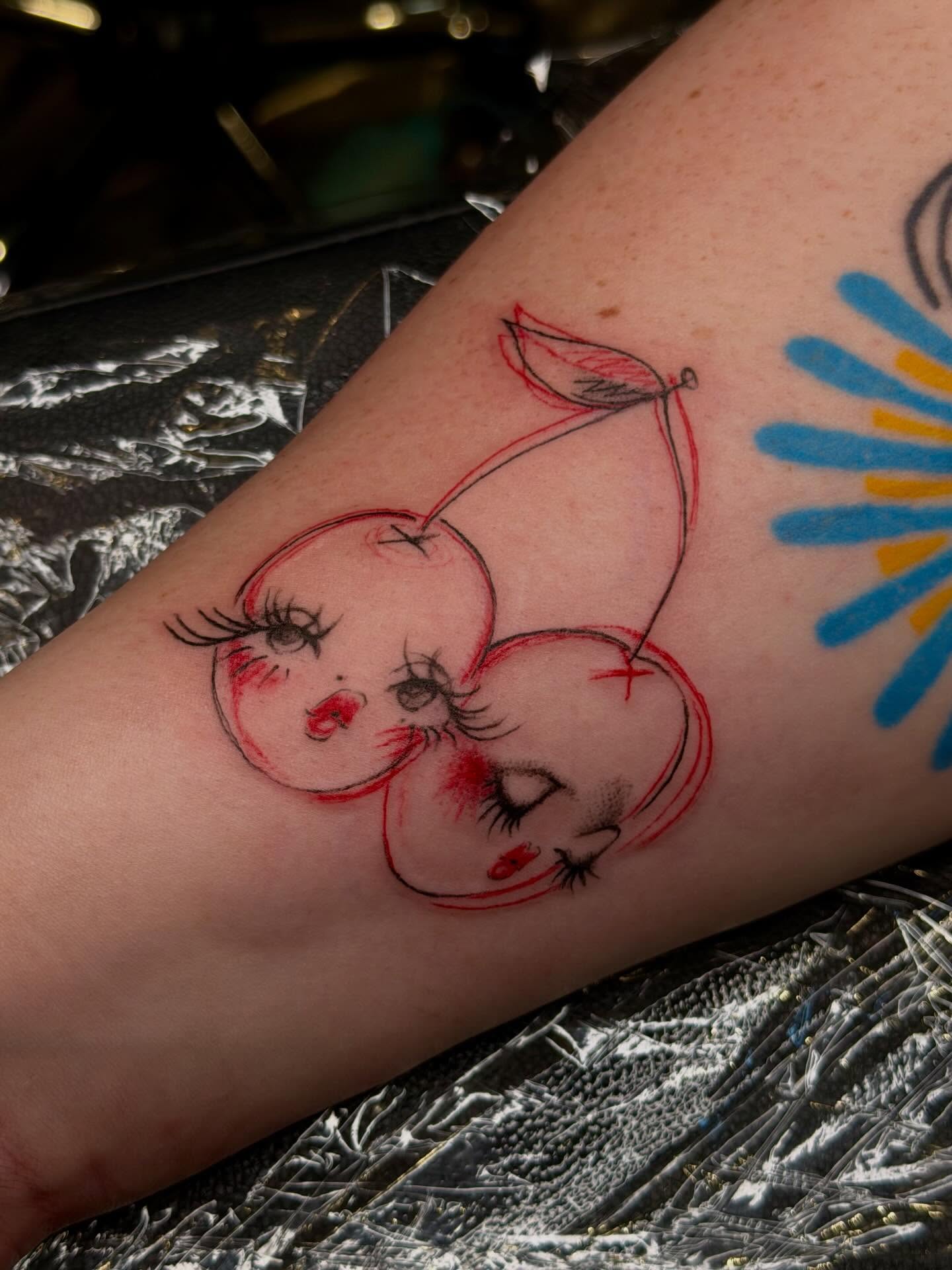 Cherry faces illustrative tattoo on the forearm by tattooz by megz