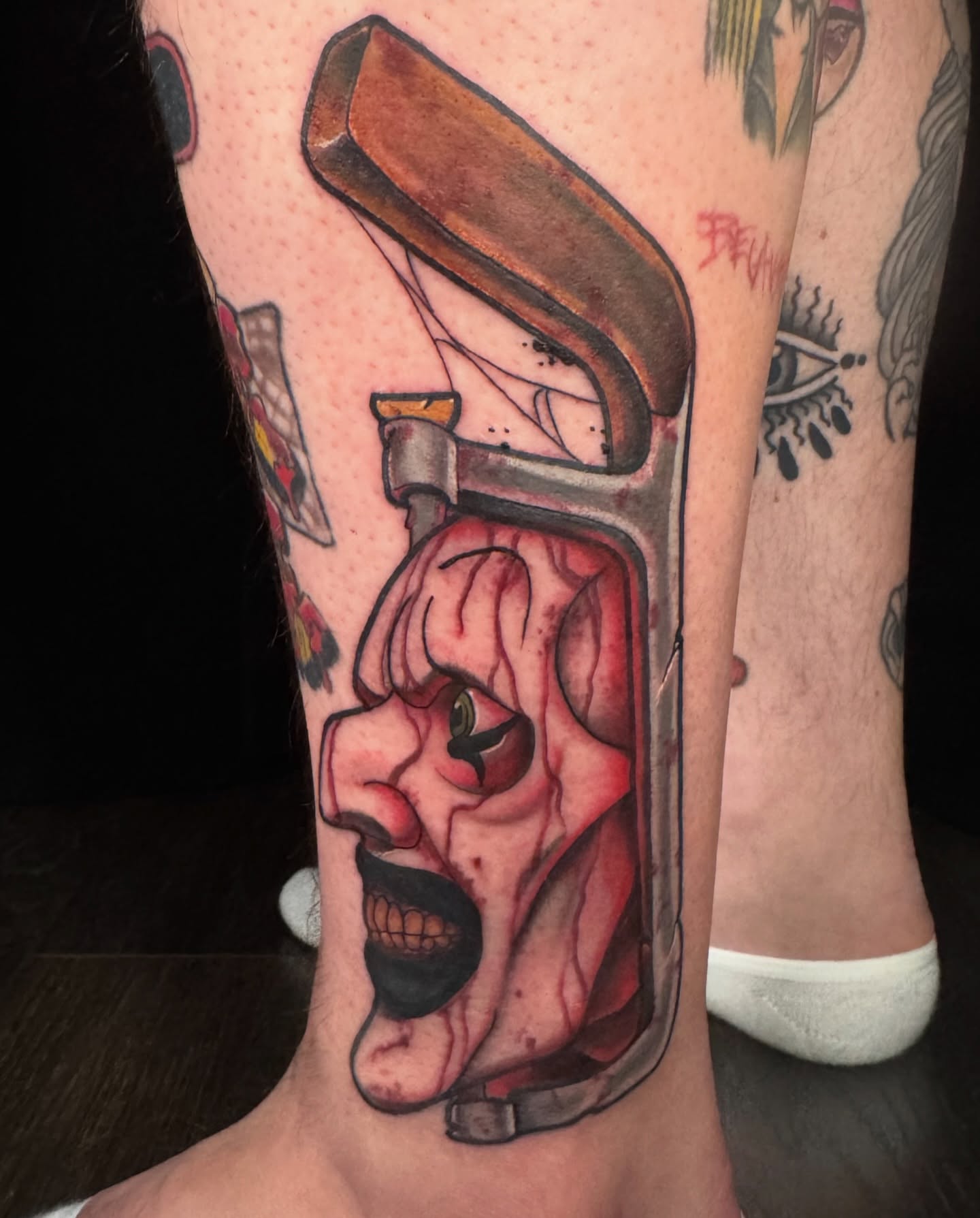 Screaming clown face American traditional tattoo on the calf by Sideshow Danny