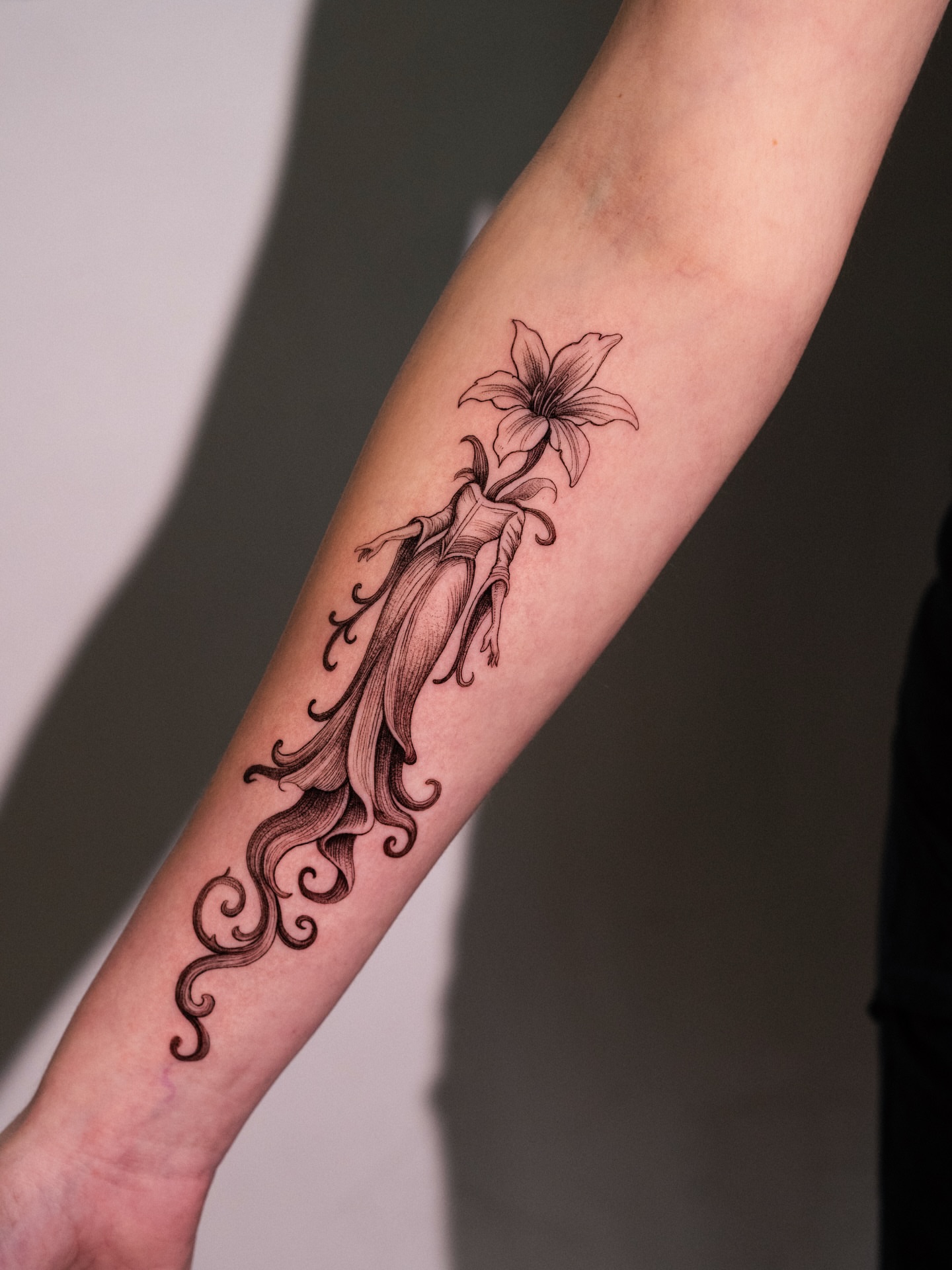 Lily black and grey tattoo on the forearm by Brad Simmons