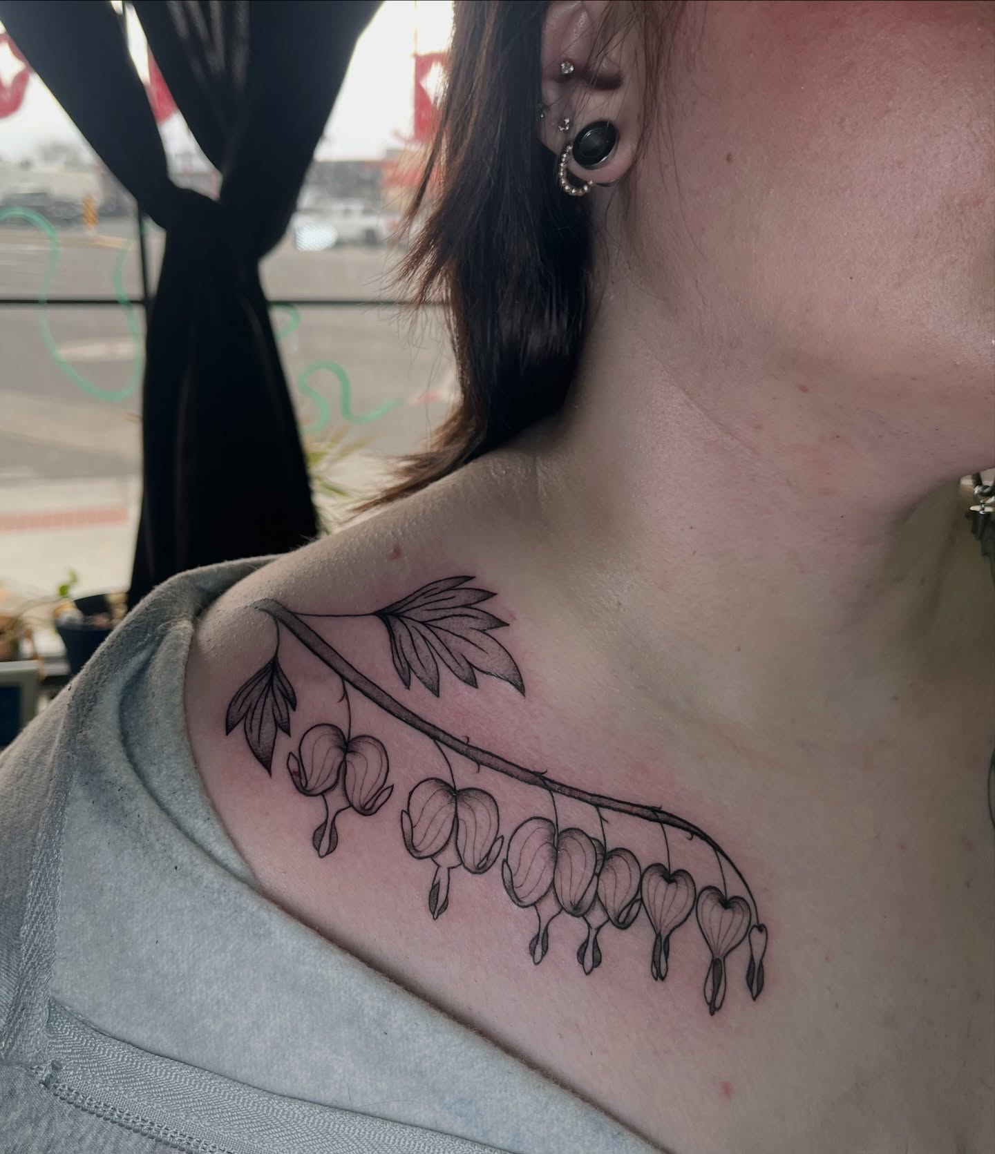Bleeding heart plant black and grey tattoo on the shoulder by Daniela