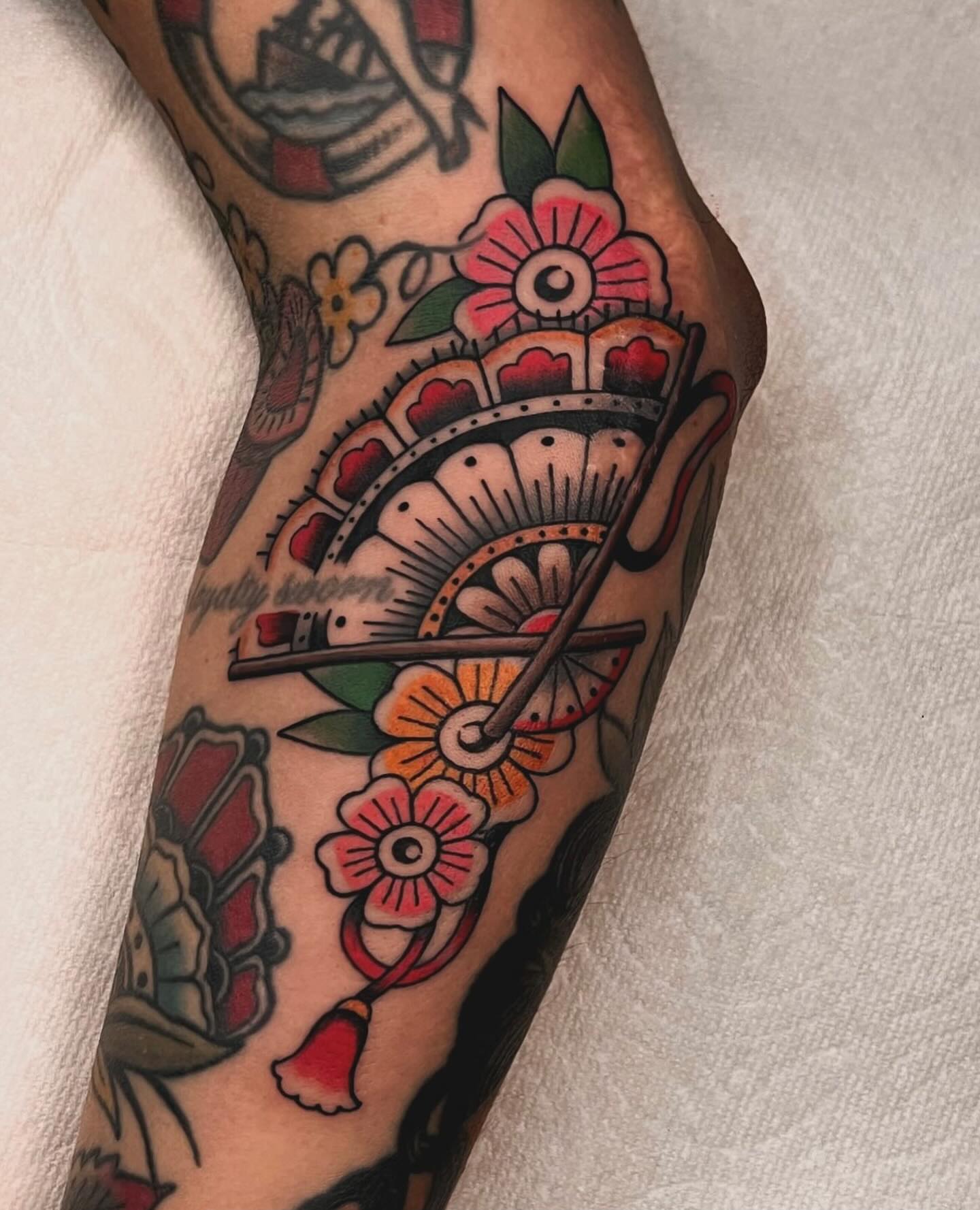 Fan and flowers American traditional tattoo on the forearm by 𝙻𝚒𝚊 𝙹𝚎𝚙𝚙𝚎𝚜𝚎𝚗