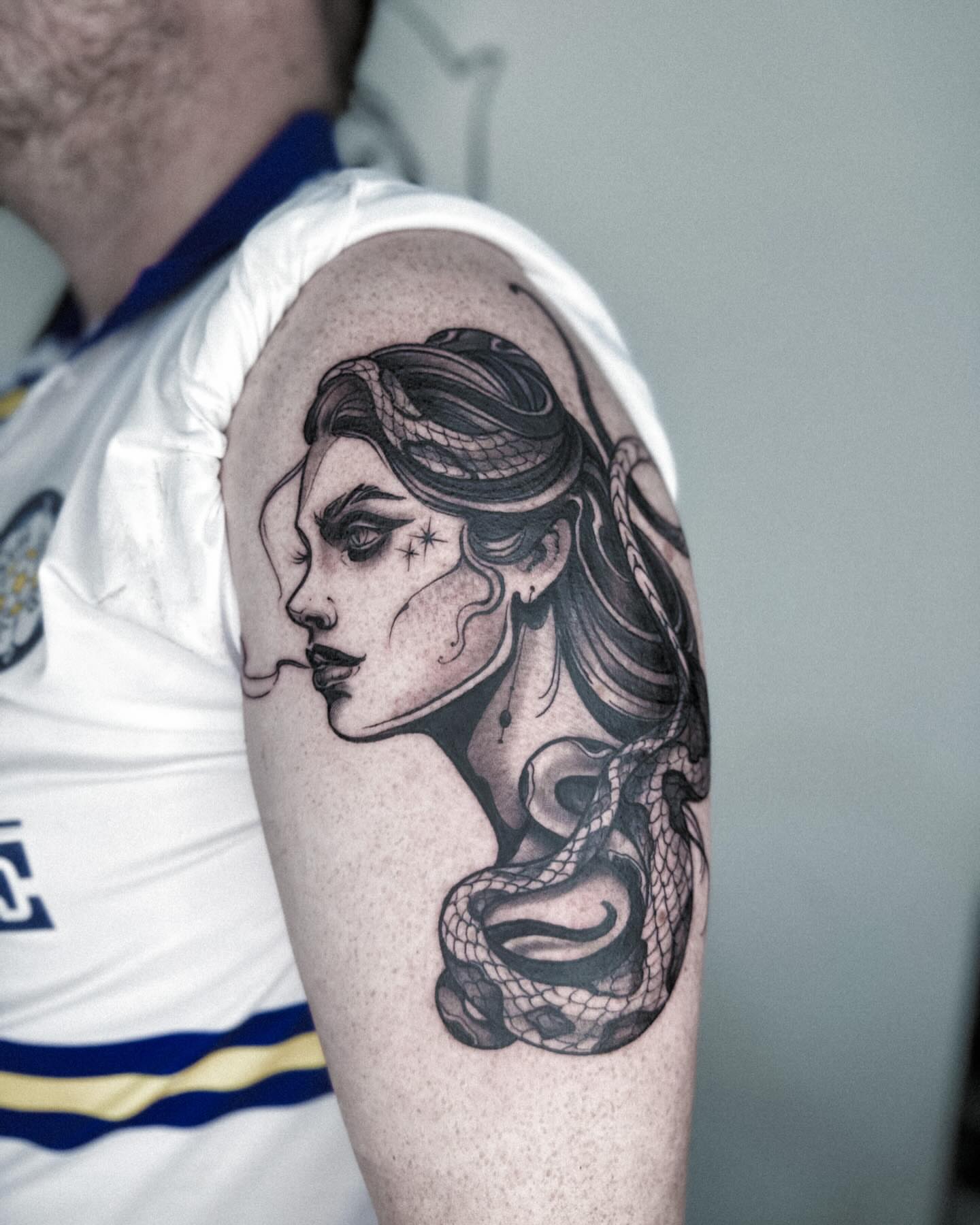 Woman with snake realism tattoo on the upper arm by Elvira Savchuk